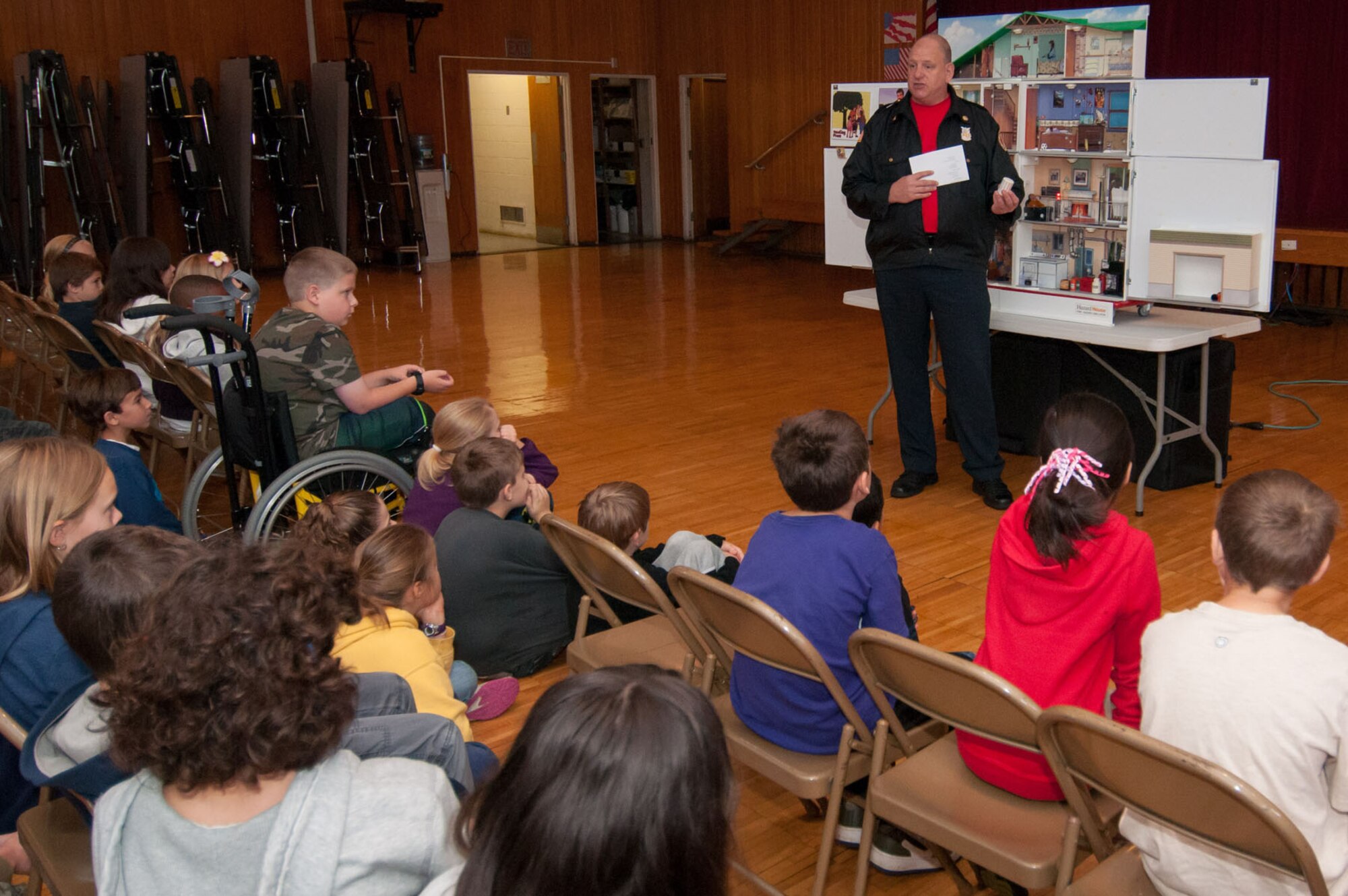 HANSCOM AIR FORCE BASE, Mass. – Assistant Fire Chief Mark Webb shows a fire safety house to students at Hanscom Middle School Oct. 10. The fire department conducted many educational events to educate and celebrate Fire Prevention Week. (U.S. Air Force photo by Rick Berry)