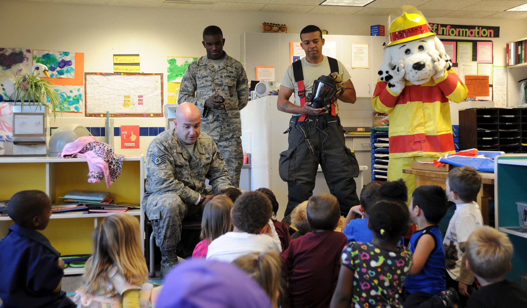 (Left to right) Staff Sgt. Thomas Barina, 22nd Civil Engineer Squadron firefighter crew chief, Airman 1st Class Jeremy McLaurin, 22nd CES firefighter, Staff Sgt. Alfred Mines, 22nd CES crew chief and “Sparky,” the fire safety dog, speak to preschool-aged children at the Child Development Center about fire safety, Oct. 10, 2012, McConnell Air Force Base, Kan. The Airmen visited the CDC to ensure the children have a fire safety plan in case of an emergency.  They also demonstrated how firefighters quickly don their safety uniform. (U.S. Air Force photo/Airman 1st Class Jose L. Leon)