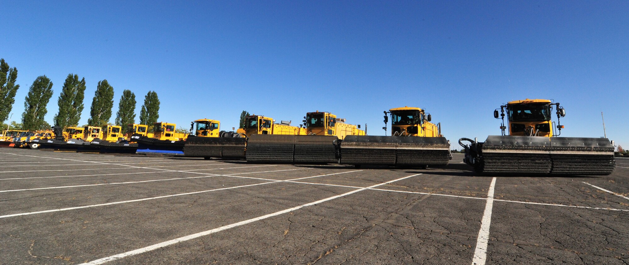 Snow removal vehicles sit in line before the start of the annual snow parade at Fairchild Air Force Base, Wash., Oct. 4, 2012. The Fairchild snow removal team uses eight snow plows, eight snow brooms, four snow blowers, three tool cats and one light plow. (U.S. Air Force photo by Airman 1st Class Taylor Curry)
