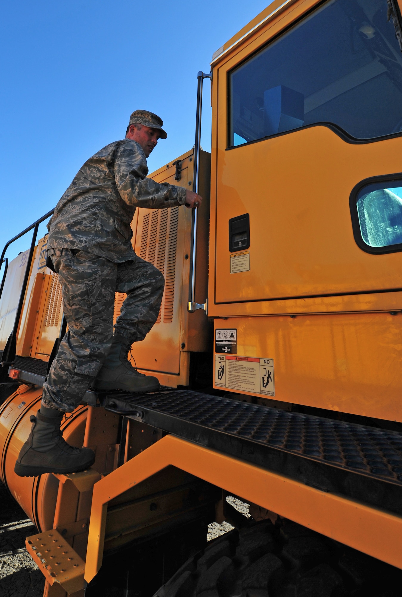 Col. Brian Newberry, 92nd Air Refueling Wing commander, enters a snow removal vehicle to drive during the annual snow parade at Fairchild Air Force Base, Wash., Oct. 4, 2012. Fairchild senior leadership inspected the readiness of the mission-critical equipment during the parade. (U.S. Air Force photo by Airman 1st Class Taylor Curry)