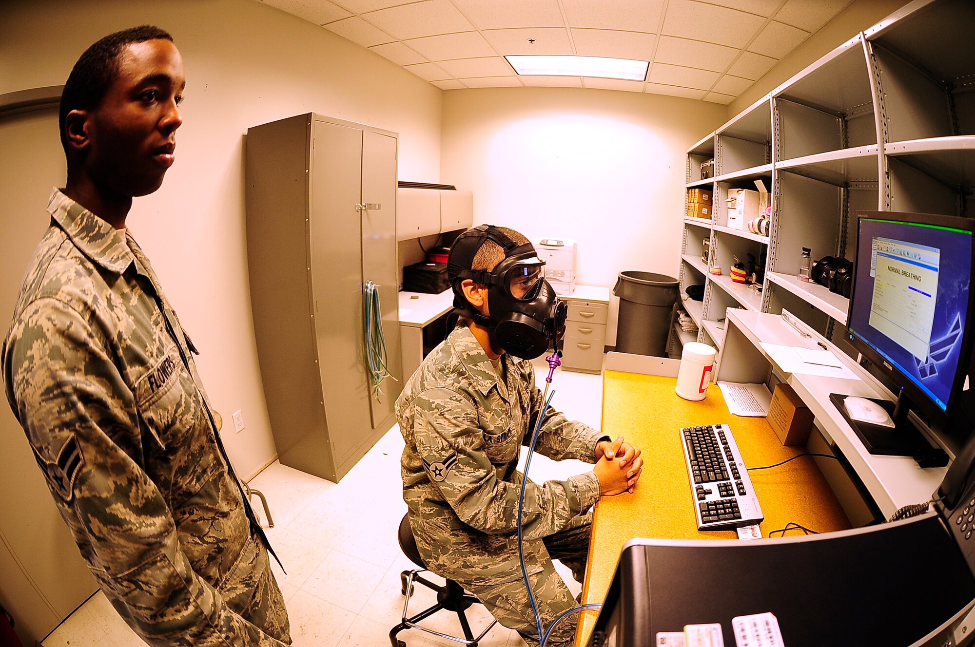 Airman 1st Class Lawrence La Strape, 509th Medical Operations Squadron bio environmental engineer, breathes into a M-50 chemical mask during a fit test administered by Airman 1st Class Joseph Flowers, 509th MDOS bioenvironmental engineer, at Whiteman Air Force Base, Mo., Oct. 3.  Fit tests ensure Airmen are able to breathe normally and are receiving proper amounts of oxygen while wearing their protective mask. (U.S. Air Force photo/Senior Airman Cody H. Ramirez)(RELEASED)