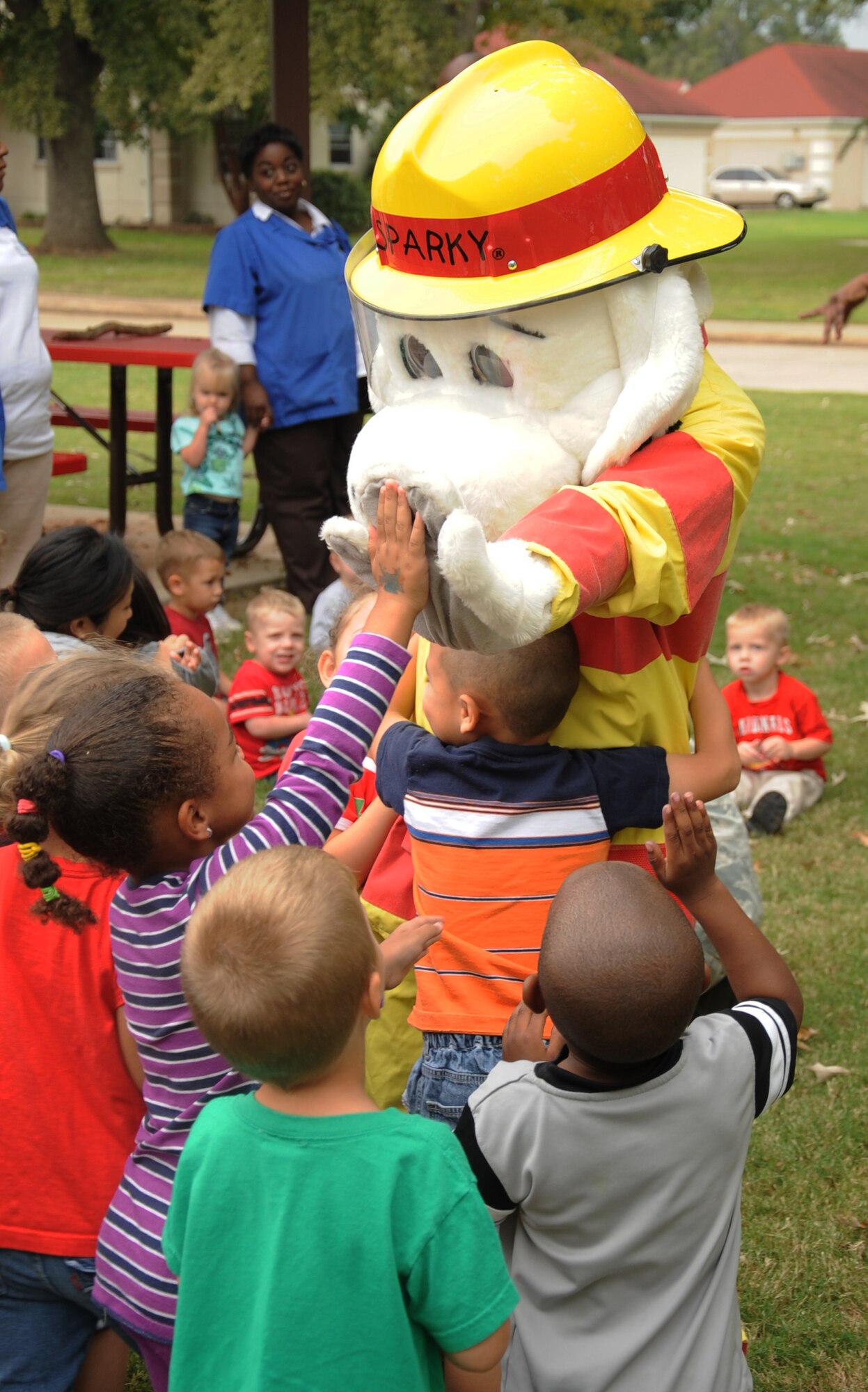 Sparky the fire dog gives a high-five to a child at the Child Development Center on Barksdale Air Force Base, La., Oct. 10. The purpose of Fire Prevention Week is to inform the Barksdale community on fire safety and useful fire prevention tips. Fire Prevention week is from Oct. 7 t0 13. (U.S. Air Force photo/Senior Airman Sean Martin) (RELEASED)