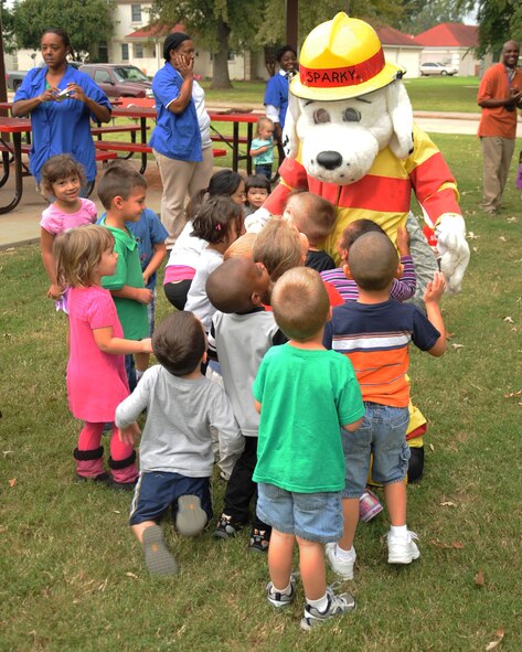 Sparky the fire dog greets children at the Child Development Center on Barksdale Air Force Base, La., Oct. 10. The 2nd Civil Engineer Squadron Fire Department conducted a fire drill at the CDC as part of Fire Prevention Week Oct. 7 to 13. (U.S. Air Force photo/Senior Airman Sean Martin) (RELEASED)