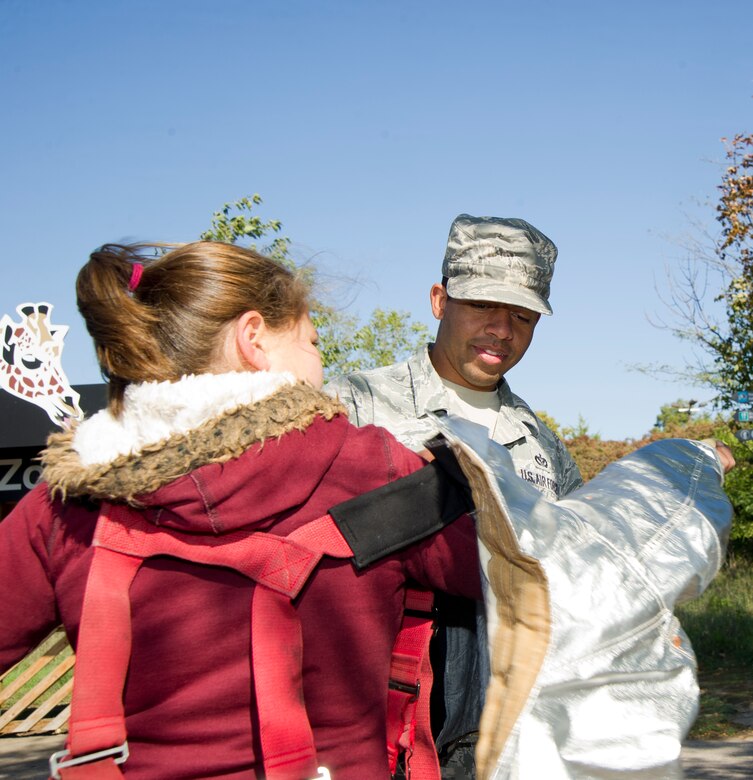 Staff Sgt. Alfred Mines, 22nd Civil Engineer Squadron firefighter, helps a child try on firefighters’ protective equipment to help promote fire safety week Oct. 9, 2012, Wichita, Kan. Several McConnell firefighters supported fire prevention week by demonstrating their equipment and personnel at the Sedgwick County Zoo. (U.S. Air Force photo/ Senior Airman Armando A. Schwier-Morales)