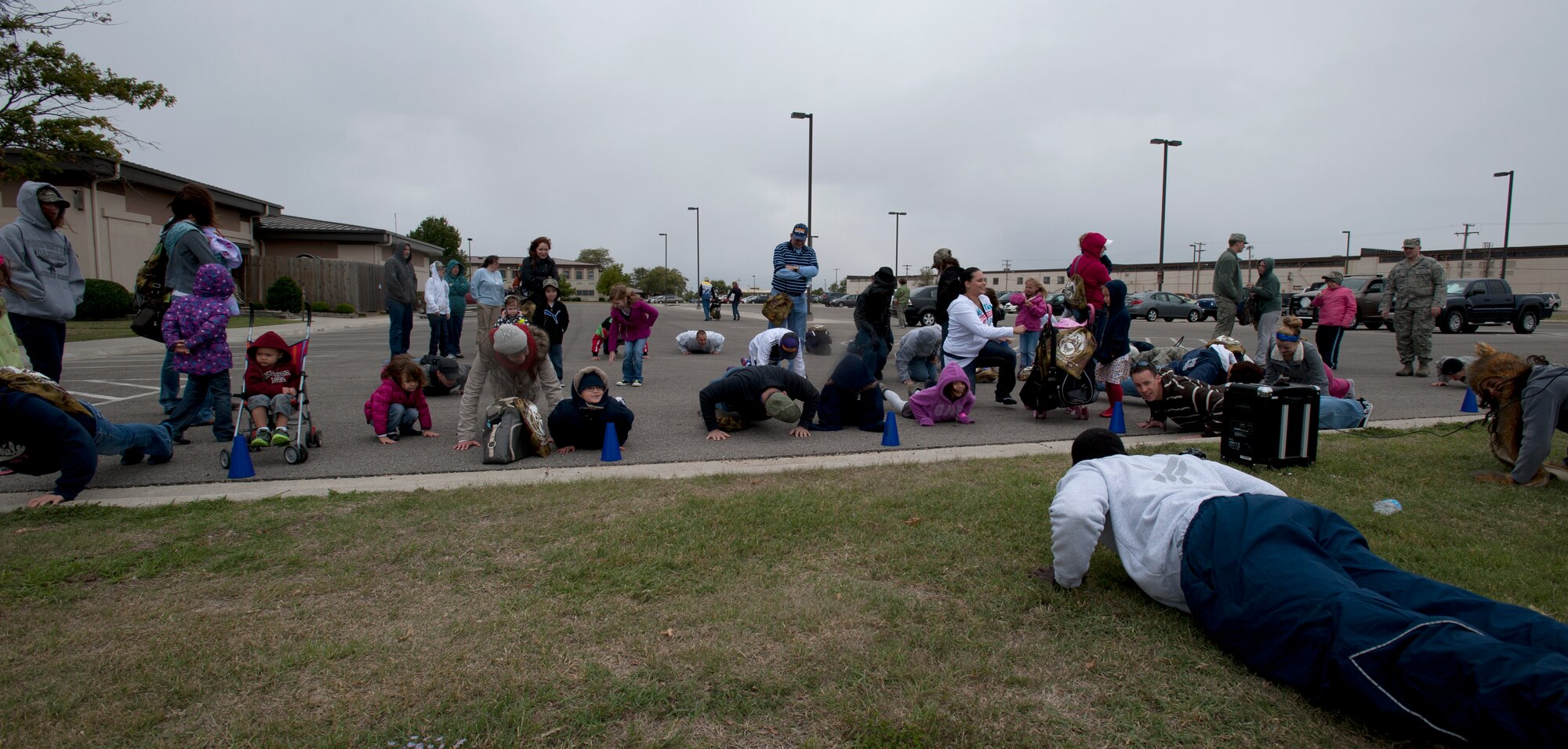 Participants of the Family Mobility Line perform pushups to stay warm as they brave the cold weather during a simulated deployment scenario Oct. 6, 2012, McConnell Air Force Base, Kan. More than 150 McConnell members and their families attended the annual event hosted by the Airman and Family Readiness Center.  (U.S. Air Force photo/Airman 1st Class Victor J. Caputo)