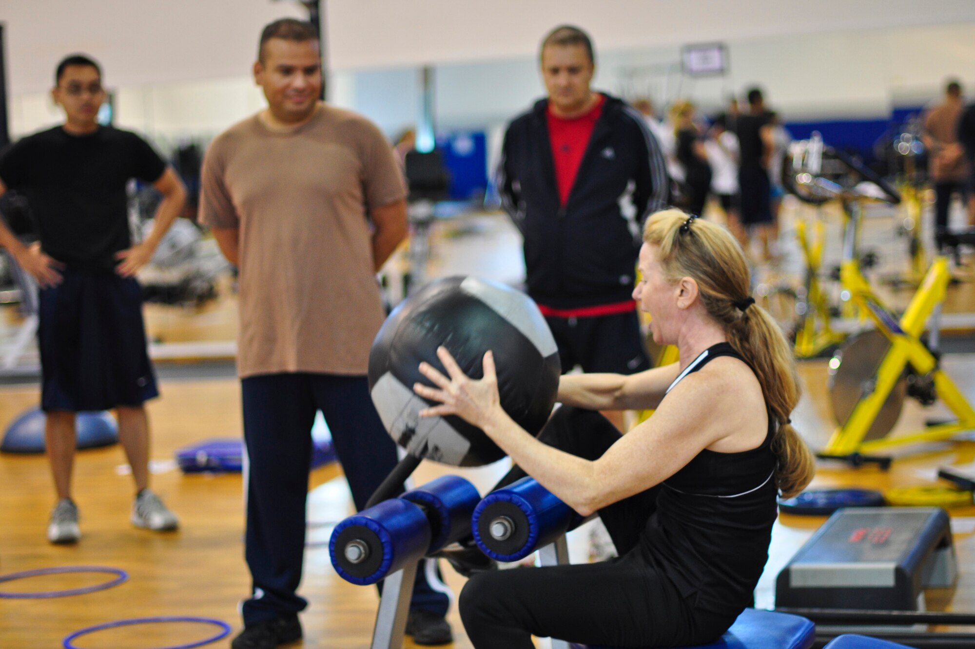 Loriann Tierney, a volunteer instructor, explains the proper form of an exercise during a PT Boot Camp class at the North Side Fitness Center at Ramstein Air Base Germany, Oct. 10, 2012. The free class runs Monday to Friday from 11:30 a.m. to 12:30 p.m., and is available for anyone who wants to participate. It offers a combination of strength training and cardio exercises to provide a total-body workout. (U.S. Air Force photo/Tech. Sgt. Chad Thompson)