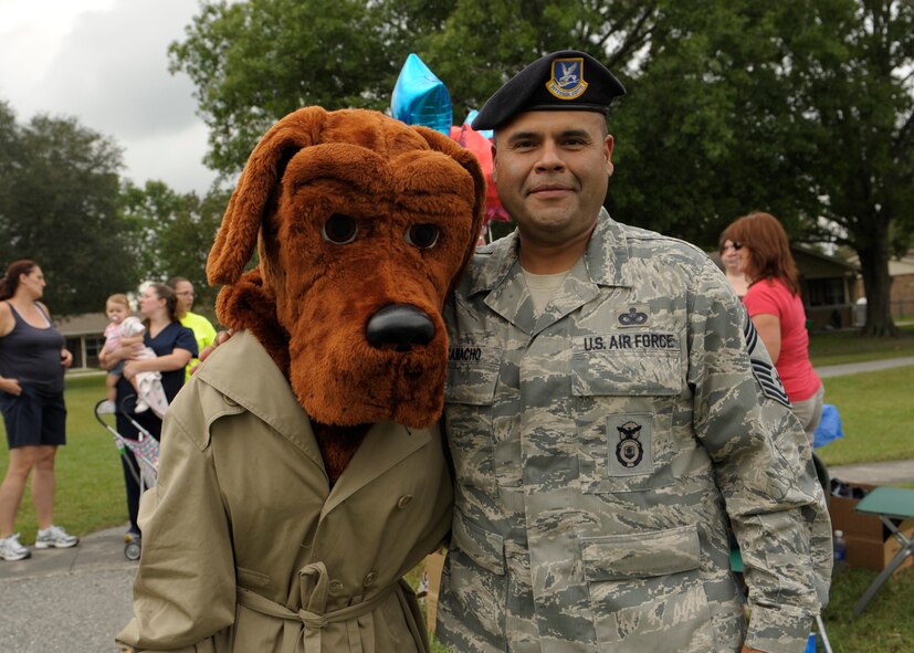U.S. Air Force Chief Master Sgt. Manuel Camacho, 23d Security Forces Squadron, poses with McGruff the Crime Dog  at the National Night Out at Moody Air Force Base, Ga., Oct. 4, 2012. Sparky the Fire Dog and others also attended to help raise awareness of neighborhood crime  nationwide, which generates support for anti-crime programs. (U.S. Air Force photo by Senior Airman Eileen Meier/Released)