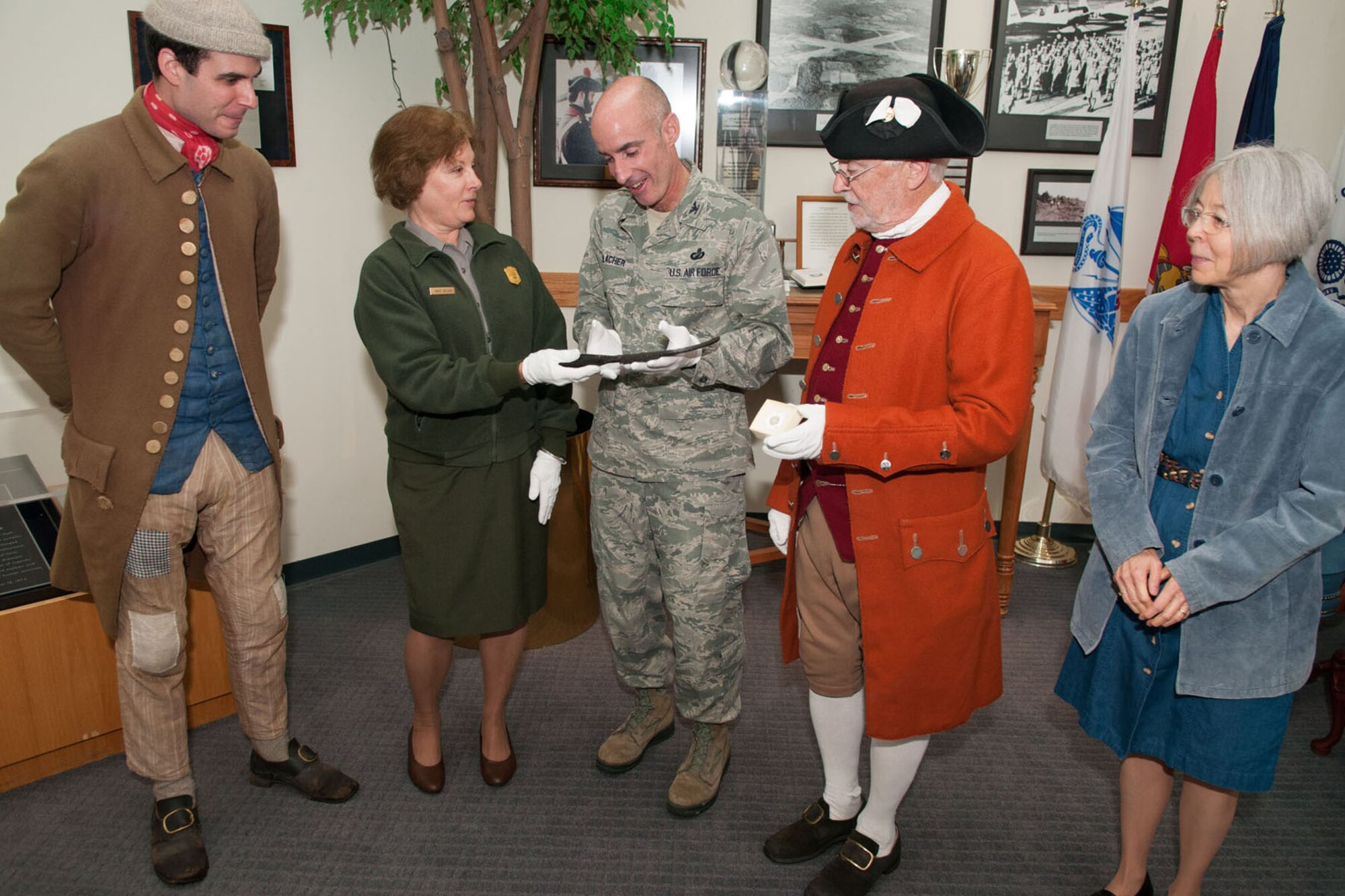 HANSCOM AIR FORCE BASE, Mass. – Col. Lester A. Weilacher (center), 66th Air Base Group commander, hands over a knife from the Revolutionary War battle of Parker’s Revenge to Nancy Nelson, Minute Man National Historical Park superintendent, during a ceremony here Oct. 3, as Lexington Minute Men Michael DaRu (left) and Bill Poole as well as Terrie Wallace, park curator, stand by. Because of Hanscom’s proximity to Revolutionary War sites, archeologists conducted a search on base and, in addition to the knife, uncovered musket balls and a shoe buckle. (U.S. Air Force photo by Rick Berry)