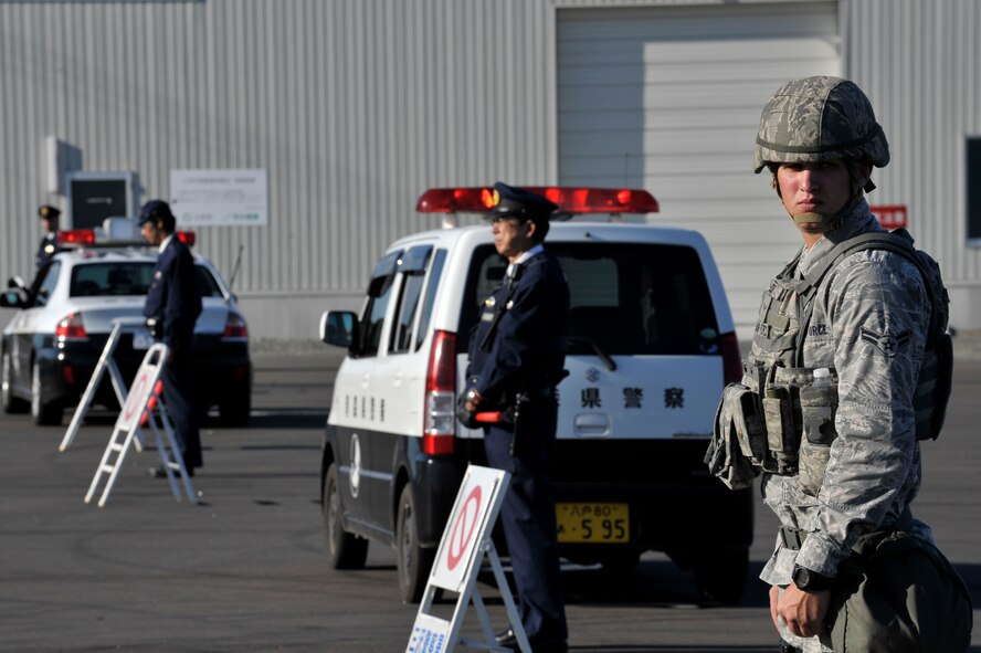 U.S. Air Force Airman 1st Class Jeffrey Scott, 35th Security Forces Squadron member, helps cordon the area where a simulated aircraft accident occurred during an Emergency Management Exercise at the Misawa City Port, Misawa, Japan, Oct. 5, 2012. Members of the 35 SFS worked alongside Misawa City police officers to provide security for the site.  (U.S. Air Force photo by Staff Sgt. Nathan Lipscomb)