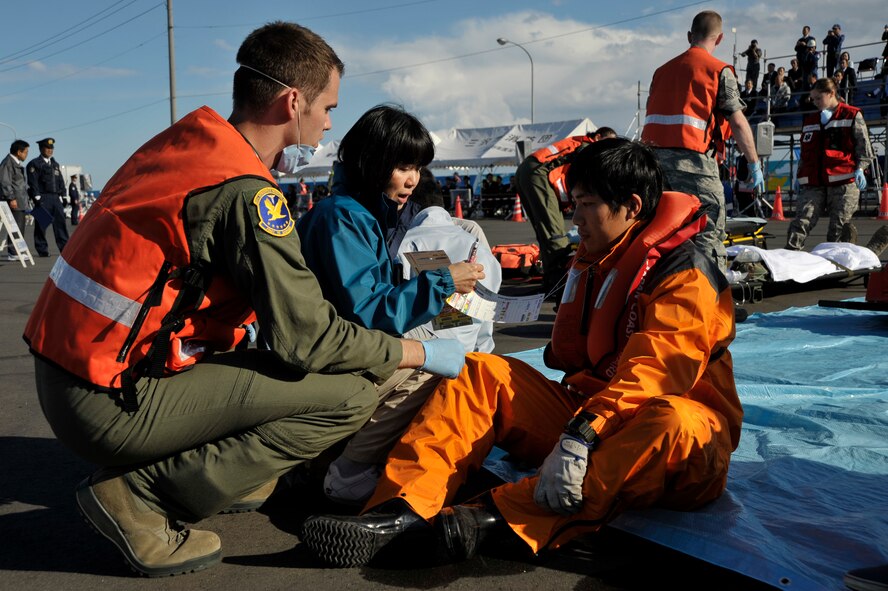 U.S. Air Force Capt. Matthew Wimmer, left, 35th Aerospace Medical Squadron flight medicine doctor, assesses the injuries of a simulated accident victim during an Emergency Management Exercise at the Misawa City Port, Misawa, Japan, Oct. 5, 2012. Personnel from the 35th Medical Group responded to the scene to provide medical care for victims of a simulated aircraft accident. (U.S. Air Force photo by Staff Sgt. Nathan Lipscomb)