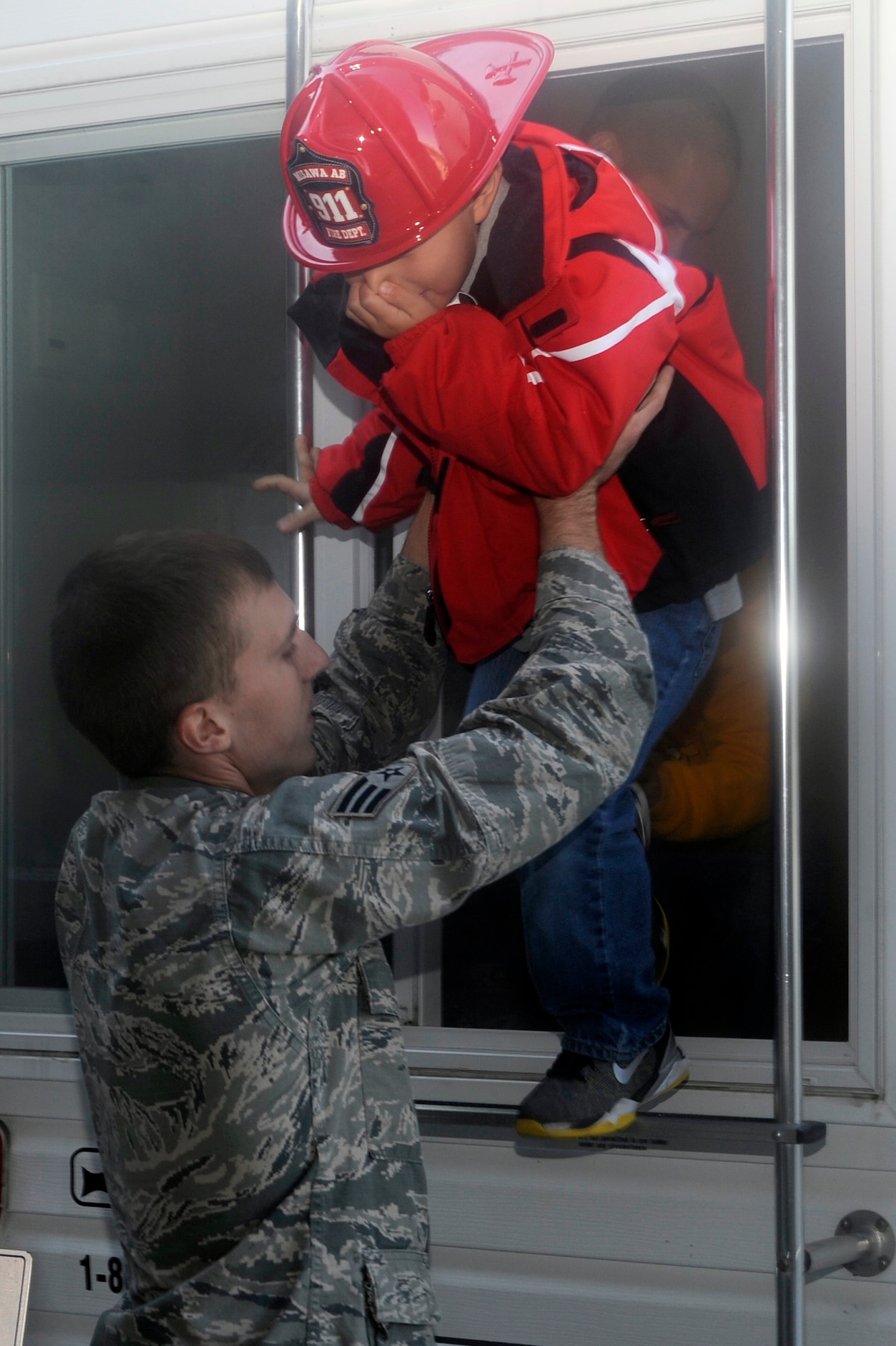 U.S. Air Force Senior Airman Seth Arbogast, 35th Civil Engineer Squadron firefighter, helps a first grade student from Sollars Elementary School escape a simulated burning building at Misawa Air Base, Japan, Oct. 9, 2012. In 1920, President Woodrow Wilson issued the first National Fire Prevention Day proclamation, and since 1922, Fire Prevention Week has been observed on the Sunday through Saturday period in which October 9 falls. (U.S. Air Force photo by Tech. Sgt. Marie Brown)