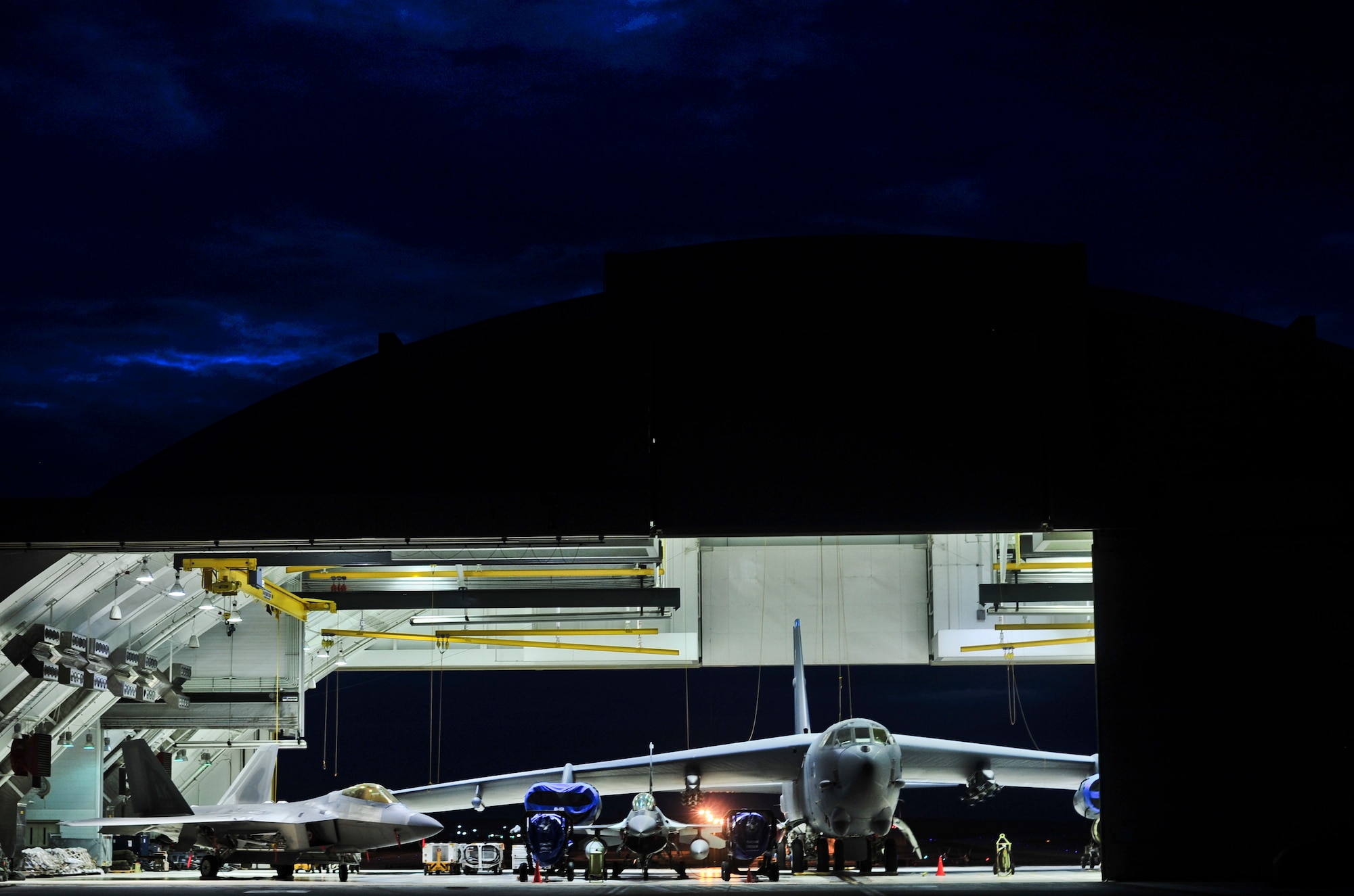ANDERSEN AIR FORCE BASE, Guam—An F-22 Raptor, F-16 Aggressor and B-52 Stratofortress sit in a hangar during inclement weather here Oct. 5. The aircraft were being stored as part of a Andersen Air Force Base weather contingency plan.  (U.S. Air Force photo by Staff Sgt. Alexandre Montes)