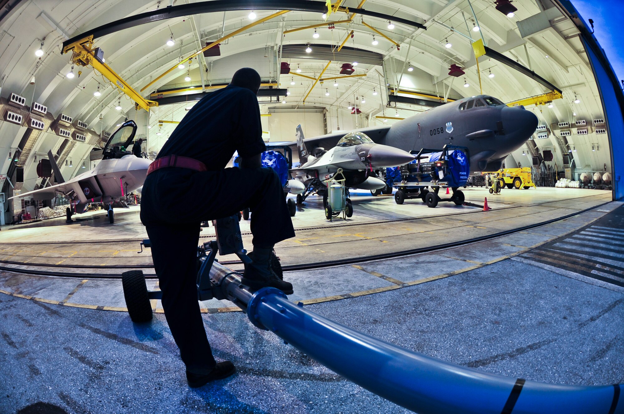 ANDERSEN AIR FORCE BASE, Guam—An Airman from the 36th Maintenance Squadron rests after helping store an F-22 Raptor, F-16 Aggressor and B-52 Stratofortress into a hangar during inclement weather here Oct. 5. The aircraft were being stored as part of an Andersen Air Force Base weather contingency plan.  (U.S. Air Force photo by Staff Sgt. Alexandre Montes) 