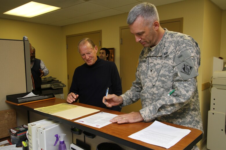 PORTSMOUTH Va. -- Sam McGee, the Craney Island facilities manager, looks on as Col. Paul Olsen signs the Voluntary Protection Program Commitment Statement affirming the district’s participation in the safety program at the Craney Island Dredge Material Management Area here. The VPP is an Occupational Safety and Health Administration program designed to make work places safer for employees through extensive documentation and modeling, which identifies problematic areas; giving employers the chance to see trends and  correct deficiencies.