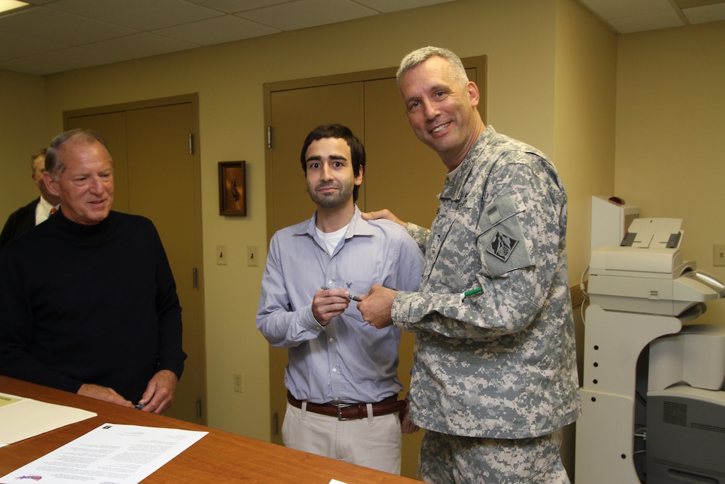 PORTSMOUTH Va. – Col. Paul Olsen presents Jorel Nadal, a district safety and health specialist, with the pen he used to sign the Voluntary Protection Program Commitment Statement affirming the district’s support to participate in the safety program at the Craney Island Dredge Material Management Area here. Nadal worked to get the program off the ground at the facility, which will make the area safer for employees through extensive documentation and modeling, which identifies problematic areas; giving employers the chance to see trends and correct deficiencies.