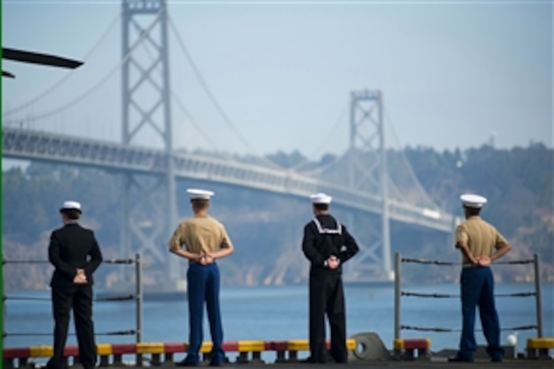 Navy sailors and Marines man the rails of the amphibious assault ship USS Makin Island as the ship passes under the San Francisco Bay Bridge at the end of San Francisco Fleet Week 2012 in San Francisco, Oct. 9, 2012. The event, which ran from Oct. 3-8, brought more than 2,500 sailors, Marines and Coast Guardsmen from four ships to the city.