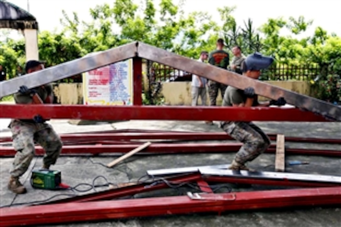U.S. Marine Corps Lance Cpls. Shane Holum, right, and Andrew Enriquez carry a beam to a construction site at a school in Barangay Dallipawen, San Narciso, Zambales, Philippines, Oct. 1, 2012. Holum and Enriquez are assigned to Marine Wing Support Squadron 172. 