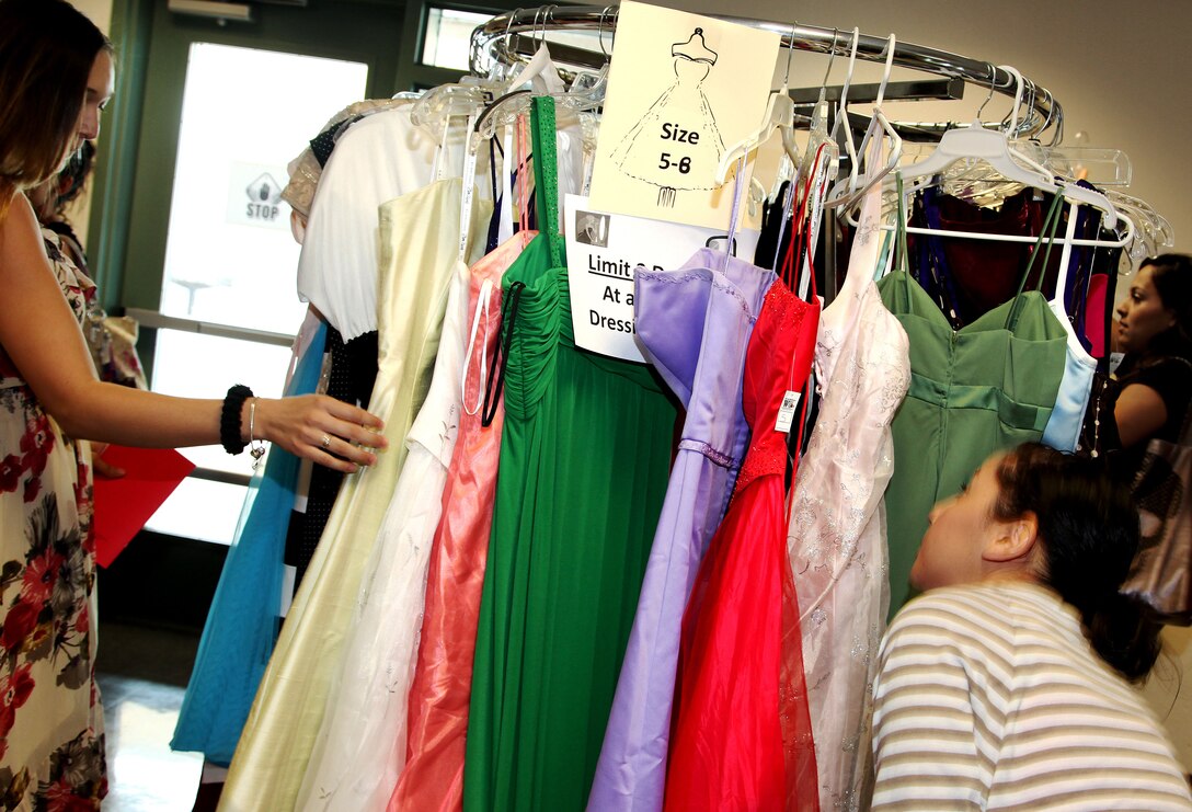 Marine wives and girlfriends shop through complimentary dresses Saturday, during the first Belle of the Ball event at the Community Center on base. The event taught formal affair etiquette to wives and girlfriends who may have never been exposed to black tie events. It also familiarized them with the Marine Corps customs and history regarding the Birthday Ball. (Official USMC photo by Lance Cpl. Lauren Kurkimilis / Released)