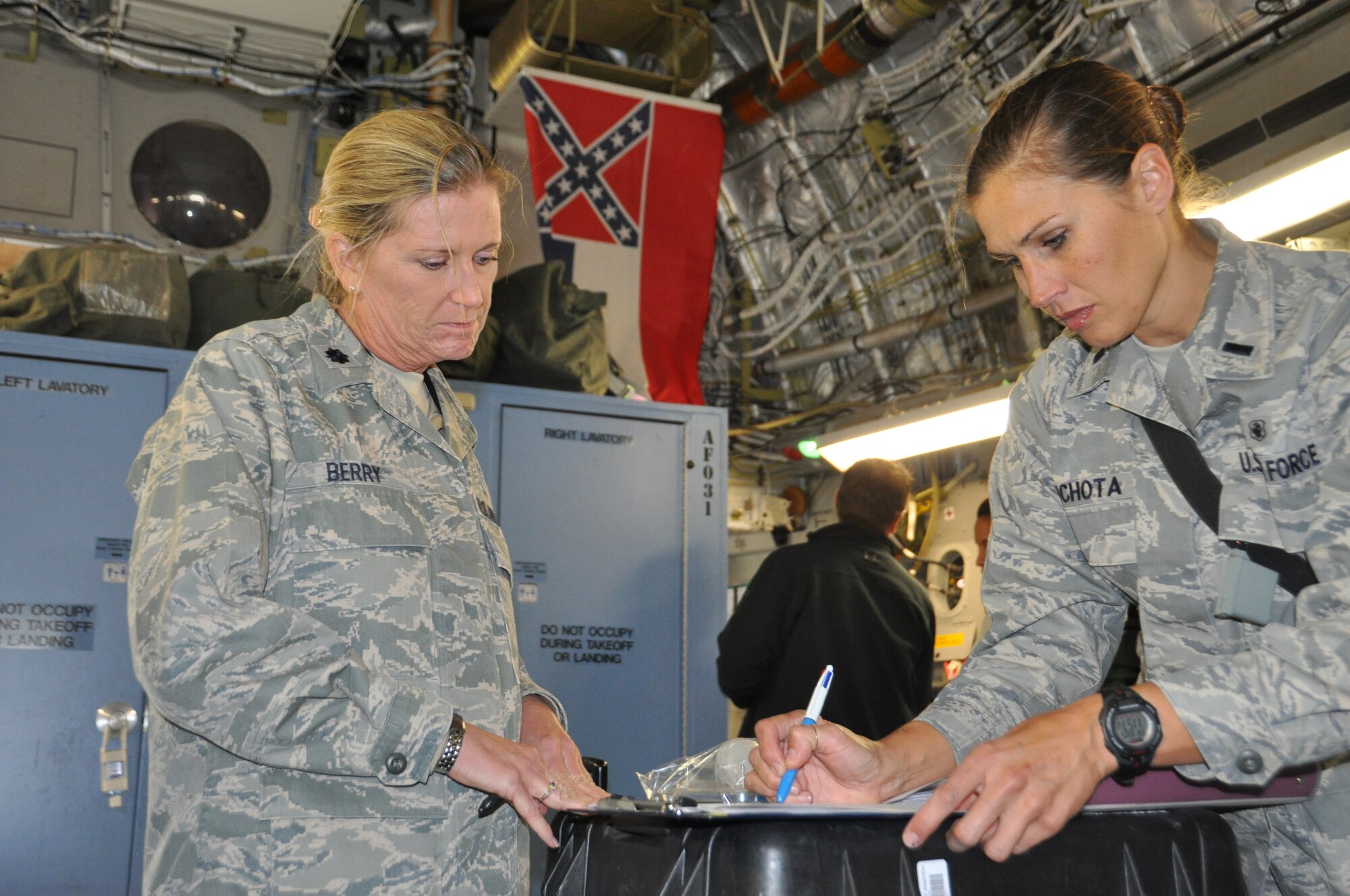 Lt. Col. Linda Berry (left) and 1st Lt Deborah Lichota, medical technicians assigned to the 86th Aeromedical Squadron at Ramstein Air Base, Germany, review each patient's record and status aboard a C-17 Globemaster II before it departs during the final leg of a MEDEVAC flight from Ramstein to the United States.  The Air Force's Strategic Transitory Care process ensures wounded warriors are kept safe and receive consistent care throughout the journey from Afghanistan through Germany to the United States. (U.S. Air Force photo/TSgt Shawn David McCowan)