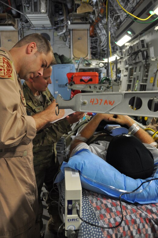 1st Lt. Rachel Hinson, a Registered Nurse at Bagram Airfield’s Contingency Aeromedical Staging Facility, passes patient information to critical care aeromedical technicians aboard a C-17 Globemaster II, prior to departure for Ramstein Air Base, Germany. The Air Force's Strategic Transitory Care process ensures wounded warriors are kept safe and receive consistent care throughout the journey from Afghanistan through Germany to the United States. (U.S. Air Force photo/TSgt Shawn David McCowan)