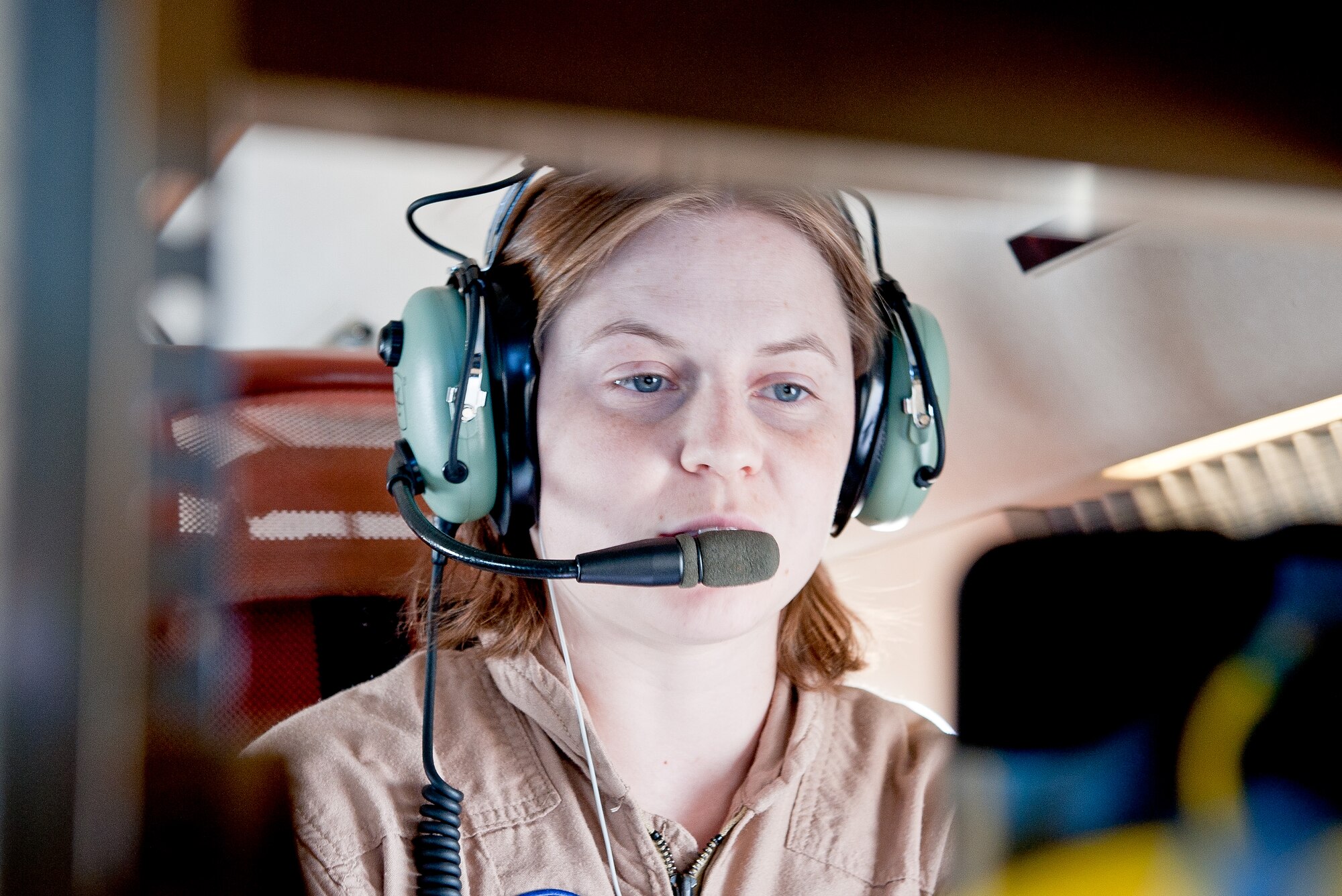 OVER JAPAN -- Brittany Martin, NASA operations engineer, communicates with a pilot via headset in a Gulfstream III over Japan during a NASA research flight Oct. 7, 2012. The NASA engineers and pilots must maintain constant communication to ensure research objectives are met. (U.S. Air Force photo by Airman 1st Class John D. Partlow)
