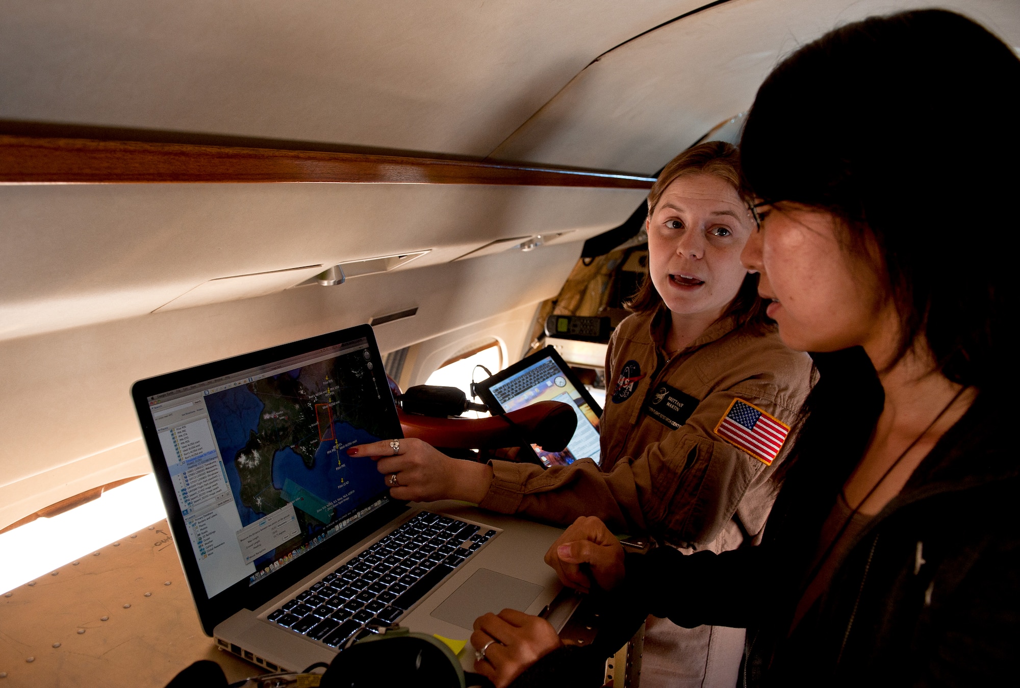 OVER JAPAN -- Center, Brittany Martin, NASA operations engineer, and Yang Zheng, NASA science coordinator and data processor, look at a map in a Gulfstream III over Japan on Oct. 7, 2012. This is the first time the team has collected data from Japan, and the information will be used for future research. (U.S. Air Force photo by Airman 1st Class John D. Partlow)