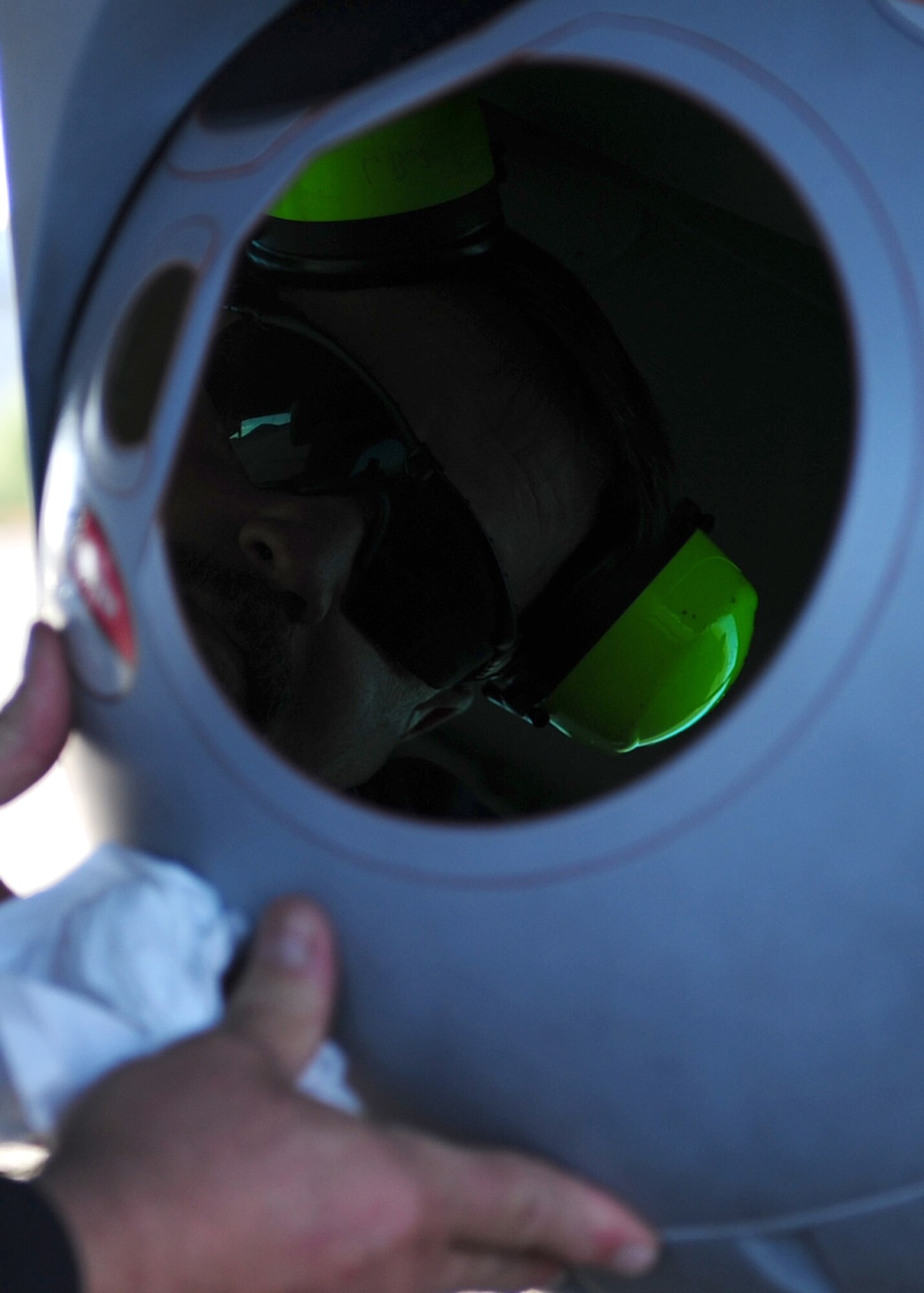 A crew chief for the Air Force MC-12W Liberty intelligence, surveillance, and reconnaissance aircraft cleans the West Cam MX-15 camera at Beale Air Force Base Oct. 9, 2012. The camera collects information which is sent via data link to geospatial analysts deployed on the ground or at the Distributed Ground Station at Beale. (U.S. Air Force photo by Senior Airman Shawn Nickel/Released)