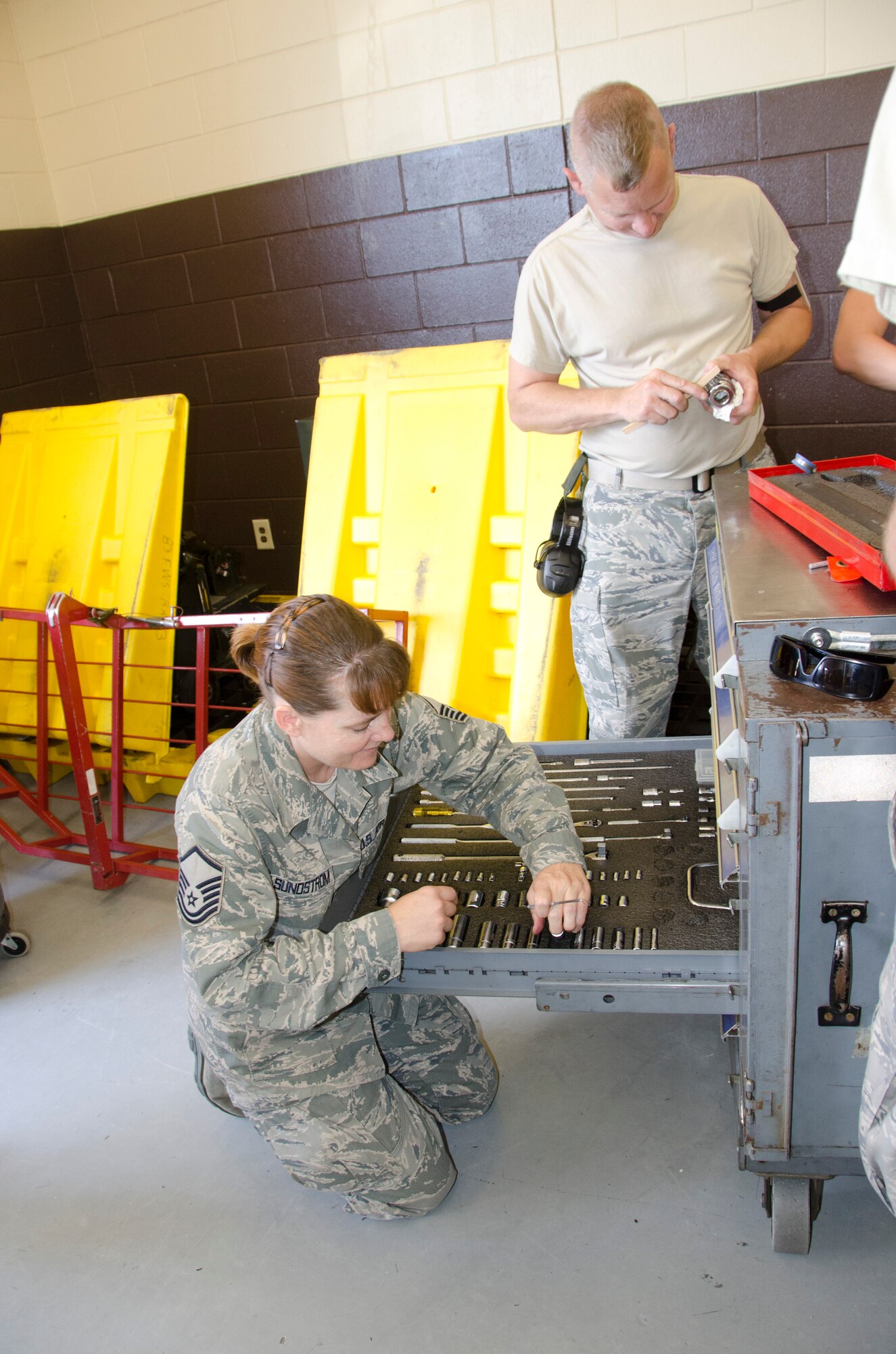 Master Sgt. Leslie Sundstrom, a 144th Fighter Wing egress craftsman, and Staff Sgt. Paul Kaupanger, a 144th Fighter Wing Hydraulics technician, clean and organize tools in preparation for the Combat Archer exercise October 6, 2012. Combat Archer is a two-week training and evaluation program for ground crews to test their maintenance systems and processes while loading live munitions on as well as critical live training for the pilots to employ air-to-air missiles against remotely piloted target drones in flight. (Air National Guard photo by Tech. Sgt. Charles Vaughn)