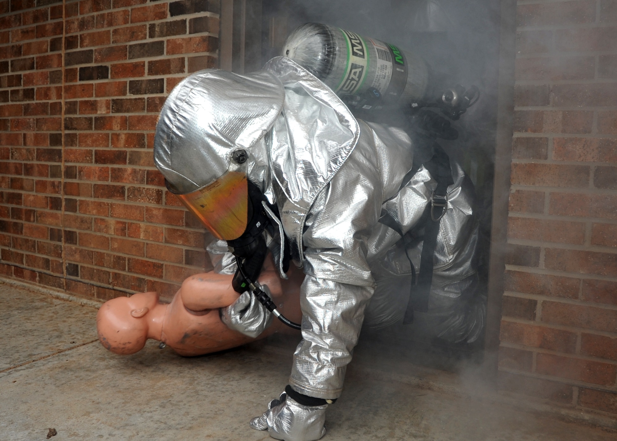 ALTUS AIR FORCE BASE, Okla. – Chief Master Sgt. David Fish, 97th Air Mobility Wing command chief, pulls a mannequin from a simulated burning building during the Group Commander’s Challenge as part of Fire Prevention Week, Oct. 11, 2012. Fish partnered with Lt. Col. Tanya Anderson, 97th Civil Engineer Squadron commander, during the simulated rescue mission to experience the difficulties firefighters face  in emergency situations. Fire Prevention Week is held annually to promote fire safety and prevention through activities and demonstrations held throughout the base. (U.S. Air Force photo by Airman 1st Class Levin Boland / Released) 