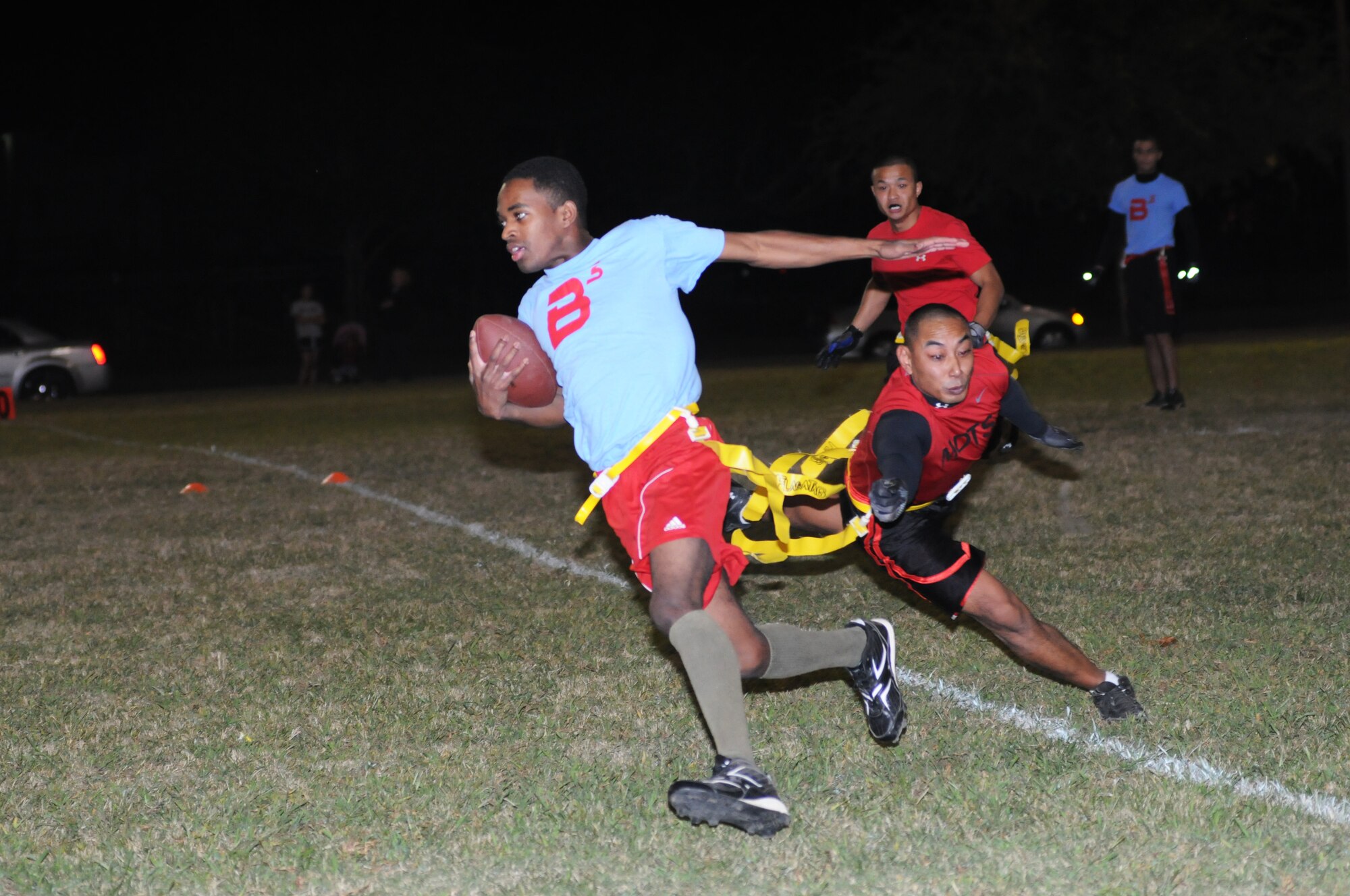 Quaci Allen, 81st Inpatient Operation Squadron, runs the ball toward the end zone as Steven Guerrero, 81st Diagnostic and Therapeutics Squadron, reaches out for his flag with his teammate, Phouthone Somchanthavong, keeping a watchful eye on him during an intramural flag football game Oct. 9, 2012, at Keesler Air Force Base, Miss.  81st MDTS defeated the 81st IPTS, 31-12.  (U.S. Air Force photo by Kemberly Groue)