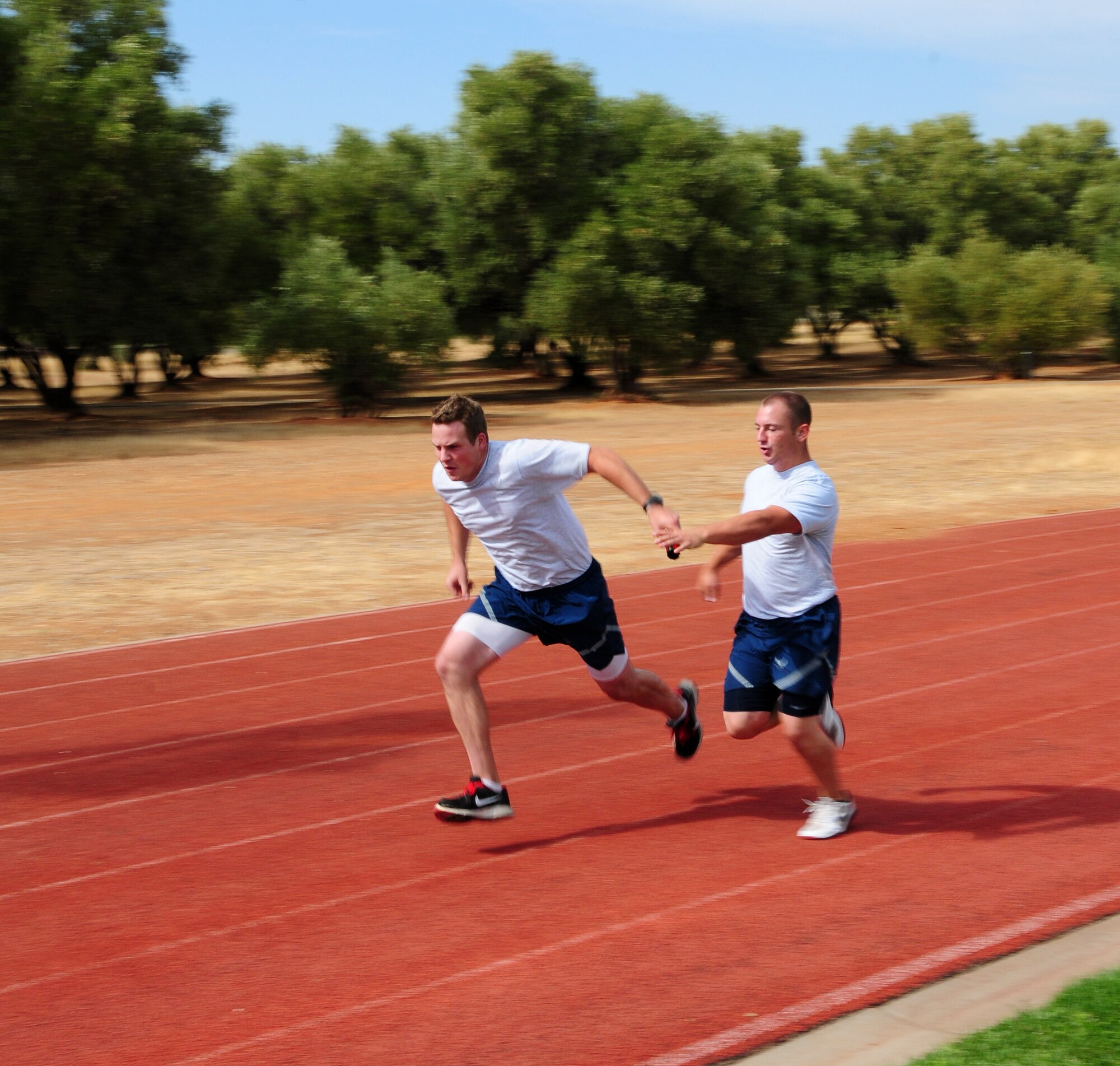 Members of Team Beale pass the baton during the base's annual sports day 400-meter relay at Beale Air Force Base Calif. Oct. 5, 2012. Each member of the four-man teams had to run 100 meters and complete a baton pass. If the baton dropped, that team was disqualified. (U.S. Air Force photo by Senior Airman Allen Pollard)