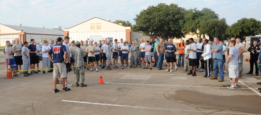 Teams competing in the  2nd Bomb Wing Annual Fire Muster Challenge listen for their completion times on Barksdale Air Force Base, La., Oct. 11. The winning team was the 2nd Medical Group. The challenge was held as part of Fire Prevention Week. (U.S. Air Force photo/Senior Airman Sean Martin)(RELEASED)
