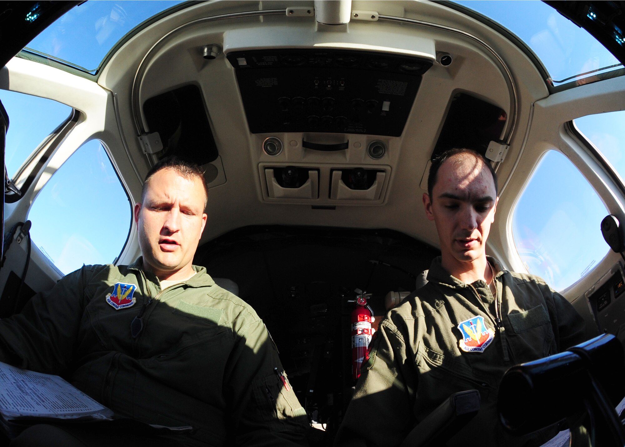 Two pilots complete a pre-flight checklist before their first flight ever in an Air Force MC-12W Liberty intelligence, surveillance, and reconnaissance aircraft at Beale Air Force Base Oct. 9, 2012. After training with the 489th Reconnaissance Squadron, the pilots will become part of the operations unit associated with the MC-12W, the 427th RS. (U.S. Air Force photo by Senior Airman Shawn Nickel/Released)