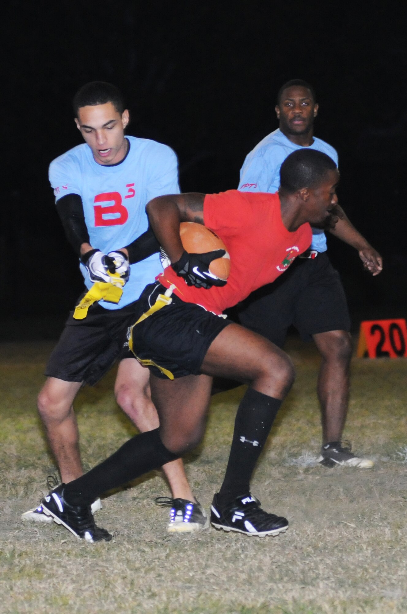 Richard Robinson, 81st Inpatient Operation Squadron, pulls the flag of Timothy Stone, 81st Diagnostic and Therapeutics Squadron, as Corey Evans, 81st IPTS, keeps an eye on the play during an intramural flag football game Oct. 9, 2012, at Keesler Air Force Base, Miss.  81st MDTS defeated the 81st IPTS, 31-12.  (U.S. Air Force photo by Kemberly Groue)