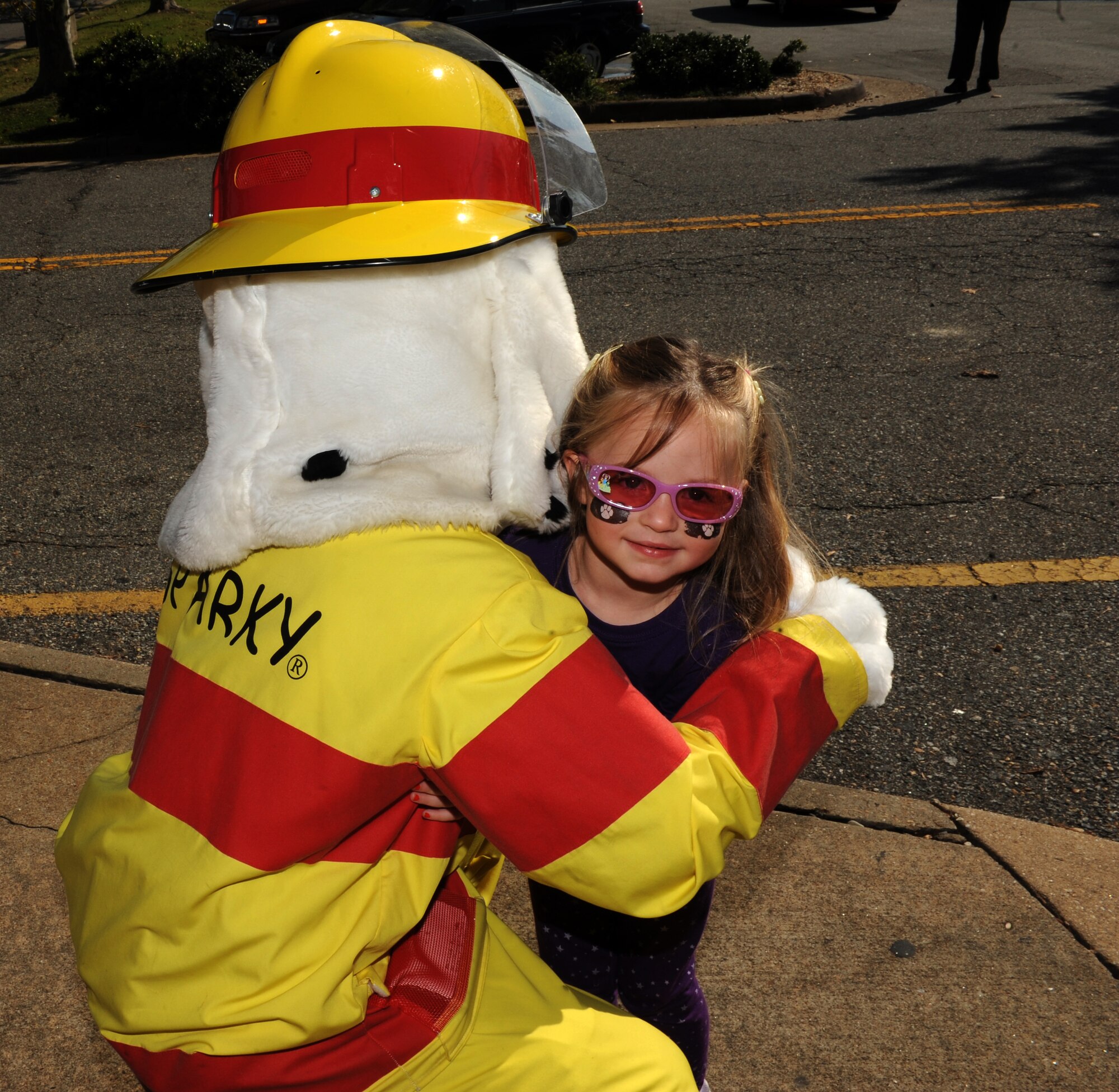 Three-year-old Addison Johnson, daughter of U.S. Air Force Tech. Sgt. Brent Johnson, hugs Sparky the Fire Dog at Langley Air Force Base, Va., Oct. 10, 2012. The 633rd Civil Engineer Squadron introduced Sparky 61 years ago to teach children safety during Fire Prevention Week. (U.S. Air Force photo by Airman 1st Class Teresa Aber/Released)