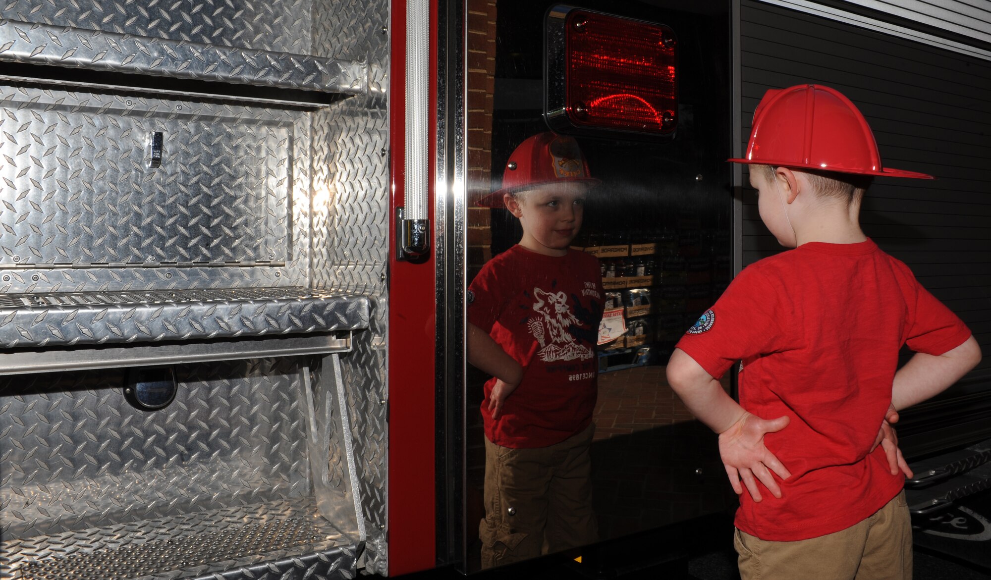 Four-year-old Jacob Beard, son of U.S. Air Force Lt. Col. Baker Beard, stares at his reflection on the side of a fire truck on display at Langley Air Force Base, Va., Oct. 10, 2012. The 633rd Civil Engineer Squadron fire department hosts the annual event to raise awareness of the importance of fire prevention and safety. (U.S. Air Force photo by Airman 1st Class Teresa Aber/Released)