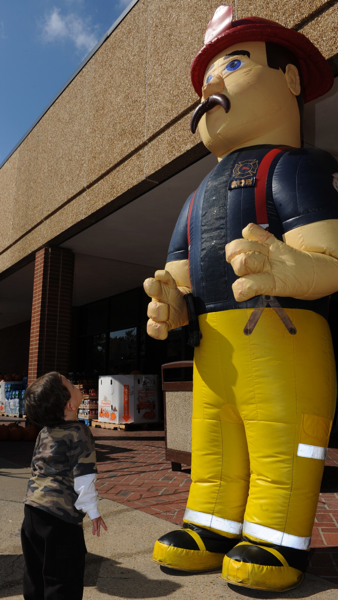 Two-year-old Jackson Boyd, son of retired U.S. Air Force Col. Benigno Ruiz, stares up at Bob the firefighter during a display at Langley Air Force Base, Va., Oct. 10, 2012. The 633rd Civil Engineer Squadron fire department visited various locations to educate about fire safety during Fire Prevention Week. (U.S. Air Force photo by Airman 1st Class Teresa Aber/Released)