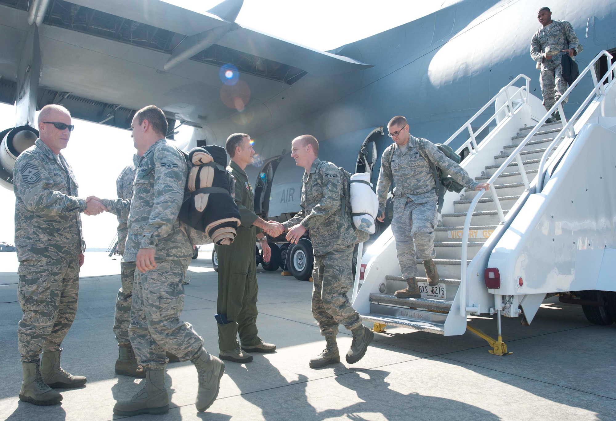 Airmen from the 75th Fighter Squadron and 23d Maintenance Group shake hands with U.S. Air Force Col. Billy Thompson, 23d Wing commander, and various base leadership as they exit a C-5 Galaxy at Moody Air Force Base, Ga., Oct. 10, 2012. The Airmen provided theater security package support for six months while deployed in Osan Air Base, Korea. (U.S. Air Force photo by Airman 1st Class Paul Francis/Released)
