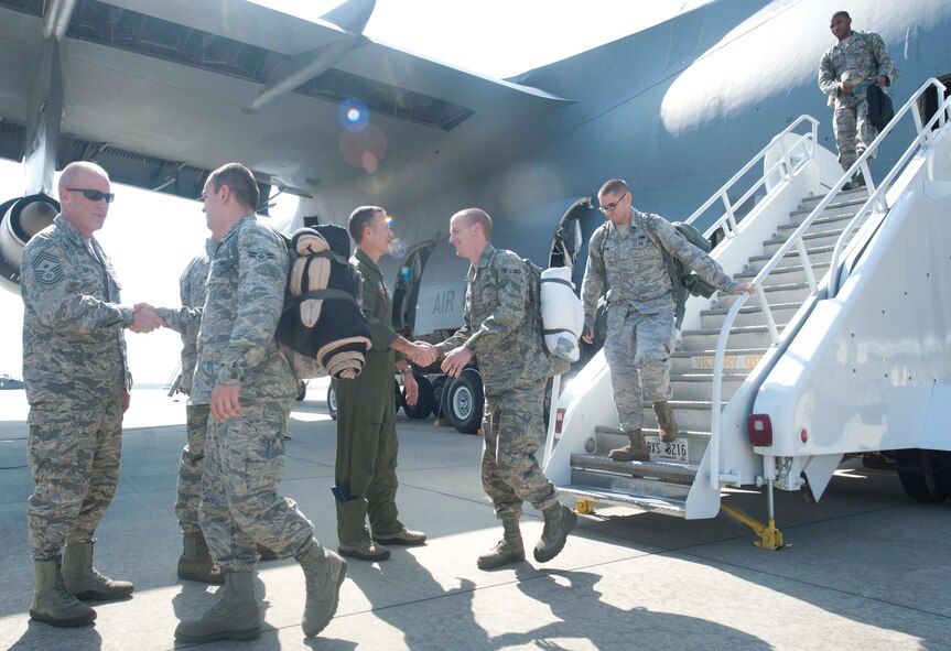 Airmen from the 75th Fighter Squadron and 23d Maintenance Group shake hands with U.S. Air Force Col. Billy Thompson, 23d Wing commander, and various base leadership as they exit a C-5 Galaxy at Moody Air Force Base, Ga., Oct. 10, 2012. The Airmen provided theater security package support for six months while deployed in Osan Air Base, Korea. (U.S. Air Force photo by Airman 1st Class Paul Francis/Released)
