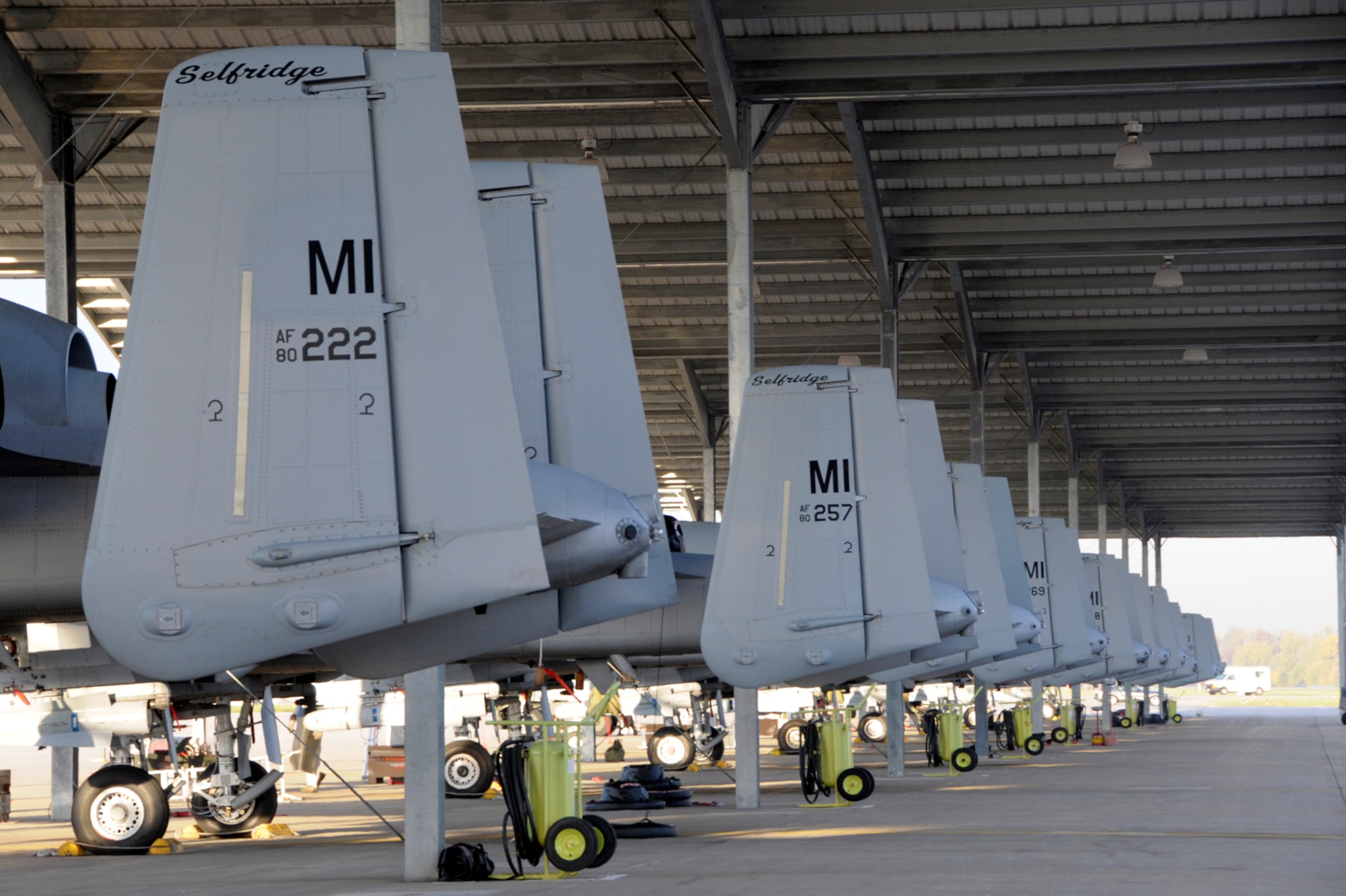 A line of twin-tailed A-10 Thunderbolt II aircraft are seen parked at Selfridge Air National Guard Base, Mich., Oct. 9, 2012. The aircraft are marked as being assigned to the base in part by the use of the "MI" on the tails of the aircraft. (Air National Guard photo illustration by Brittani Baisden)