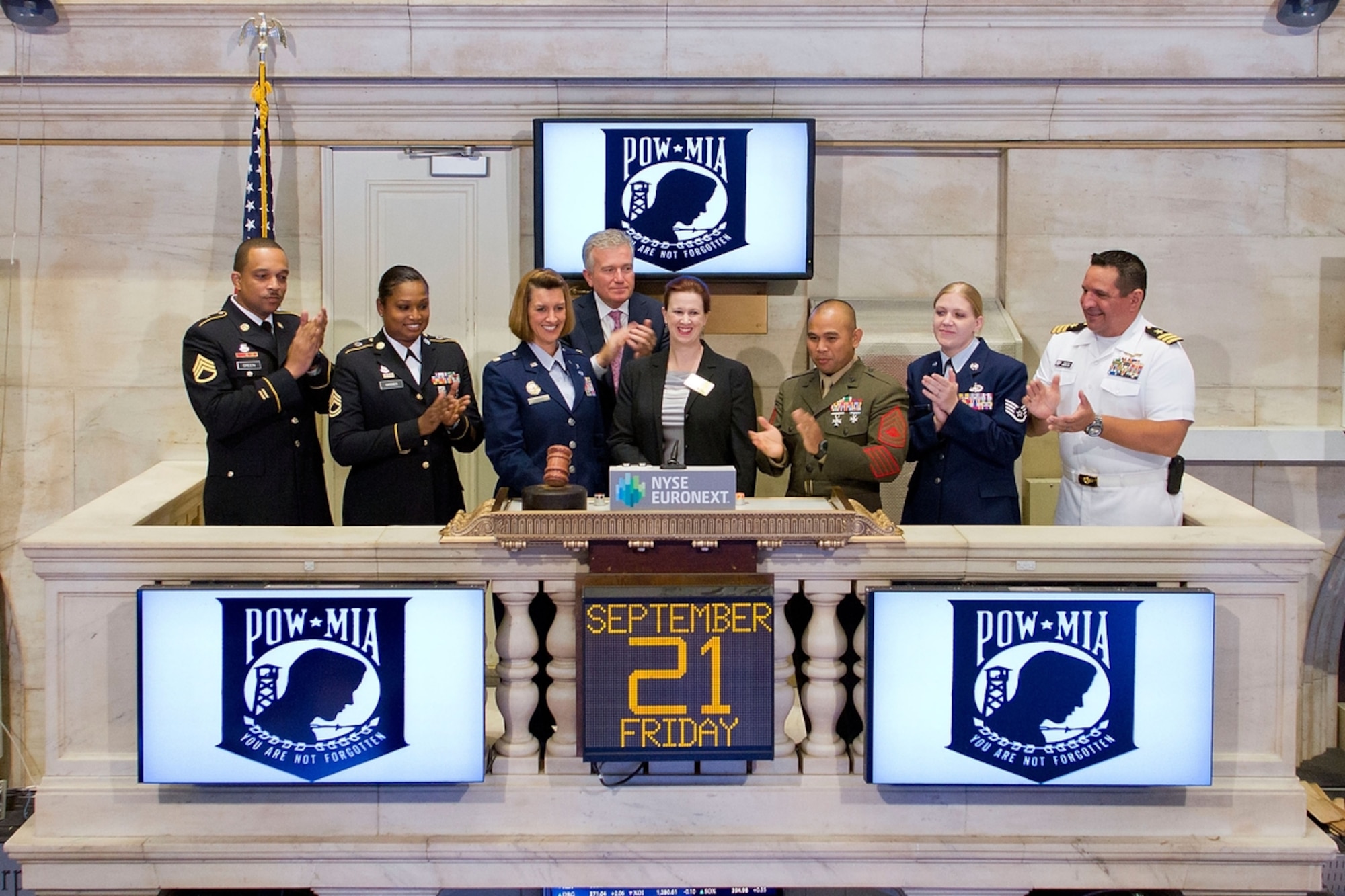 Principal Director of the Defense POW/Missing Personnel Office Ms. Alisa Stack, (center) rings the Closing Bell at the New York Stock Exchange, with Army Staff Sgt. Joseph A. Green, III, (from right to left) Army Sgt. 1st Class Alethea R. Gardner, Air Force Maj. Carie A. Parker, Marine Gunnery Sgt Harlan R. Calilao, Air Force Staff Sgt. Danielle L. Harris, and Navy CDR David J. Mendez to commemorate National POW/MIA Recognition Day on Sept. 21 with  NYSE CEO Duncan  Niederauer (back). (Photo courtesy of Defense Prisoner of War/Missing Personnel Office Public Affairs)