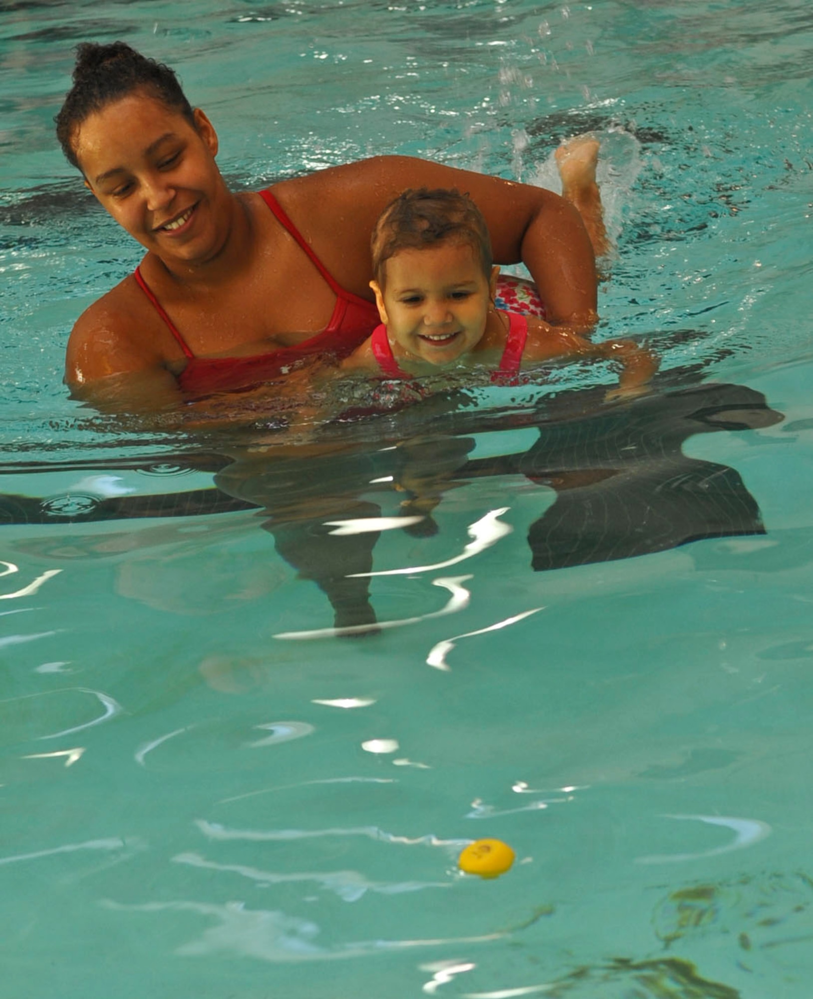 Alexis Cain, Fort Eustis Aquatic Center lifeguard, helps 3-year-old Truly Oliver swim toward a rubber duck during an “Aqua Tots” swimming class at Fort Eustis, Va., Oct. 10, 2012. Swimming classes and private lessons are available to military and civilian members of all ages at the Aquatic Center through the 2012-2013 school year. (U.S. Air Force photo by Staff Sgt. Wesley Farnsworth/Released)