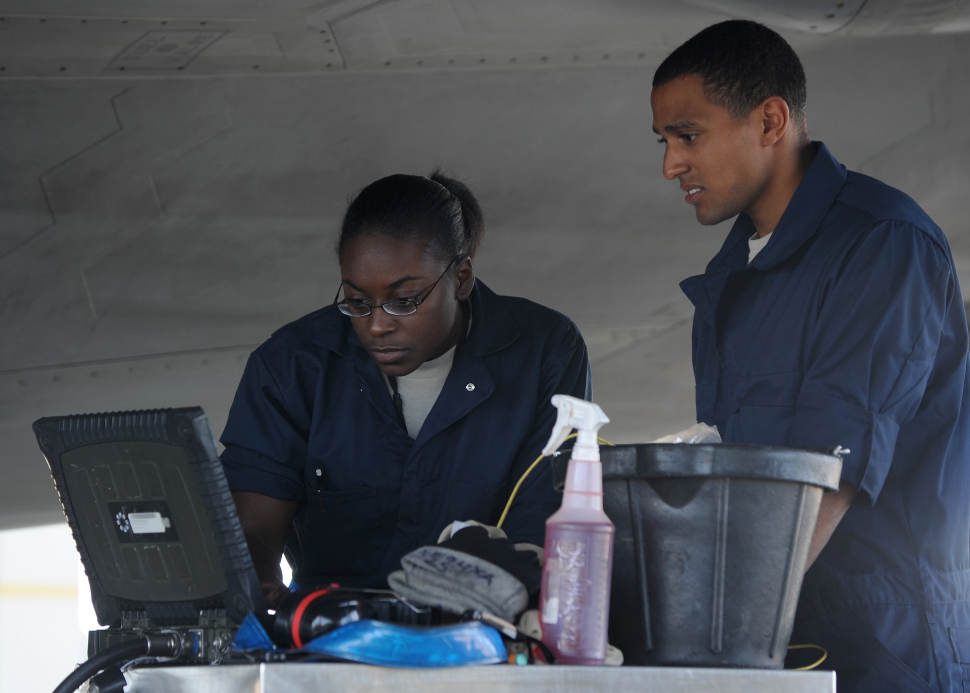 Senior Airmen Kimara Duncan, left, and Jonathan Millan refer to their computer during routine maintenance on an F-22 Raptor at Joint Base Langley-Eustis, Va., Sept. 25, 2012. Crew chiefs perform preventative maintenance, pre- and post-flight inspections, and maintain and repair the aircraft inside and out. Duncan and Millan are 94th Aircraft Maintenance Unit tactile aircraft maintainers. (U.S. Air Force photo/Senior Airman Racheal Watson)