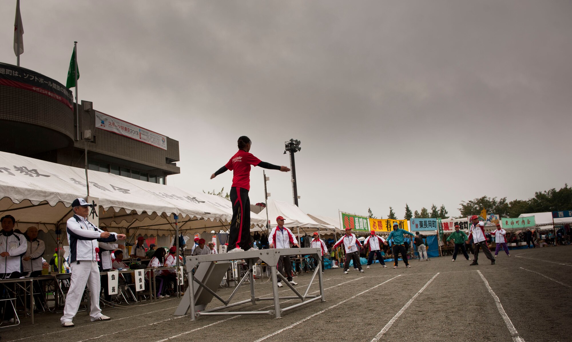 MIZUHO TOWN, Japan -- A Mizuho Town resident leads group stretches prior to the events at the Mizuho Town Sports Day, Oct. 7, 2012. Although the weather didn’t allow for a full day of sports events as planned, Airmen and their families enjoyed some Japanese food and time with the Mizuho Community. (U.S. Air Force photo by Airman 1st Class Krystal M. Garrett) 