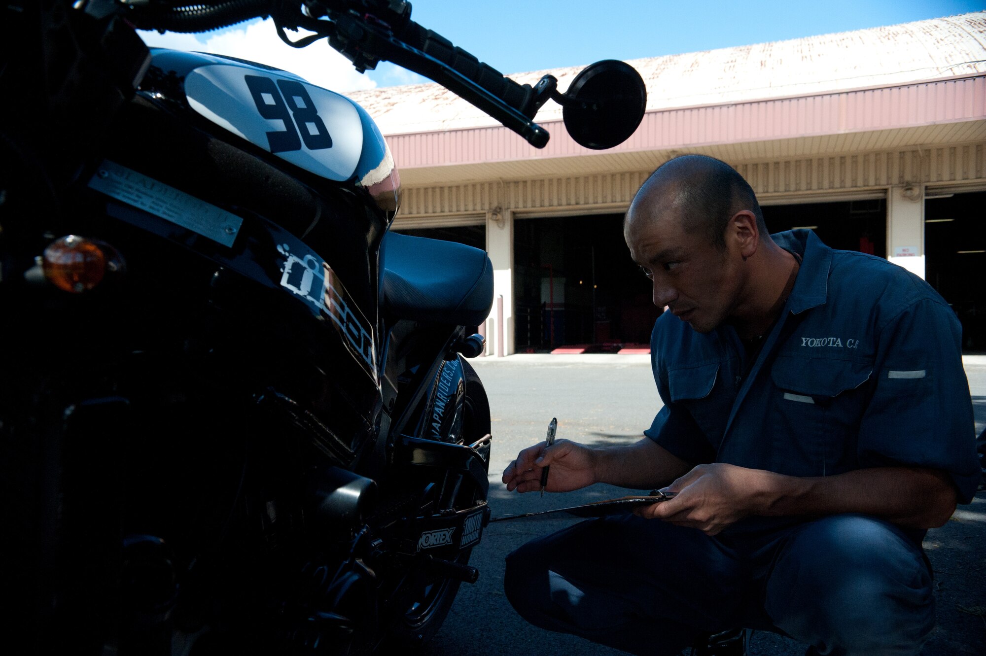 YOKOTA AIR BASE, Japan -- Mako Nomoto, Yokota Car Care Center mechanic, checks for a shift pattern decal on a motorcycle Oct. 4, 2012, at Yokota Air Base, Japan. For simple car fixes, the car care center can usually finish in one day. (U.S. Air Force photo by Airman 1st Class John D. Partlow)