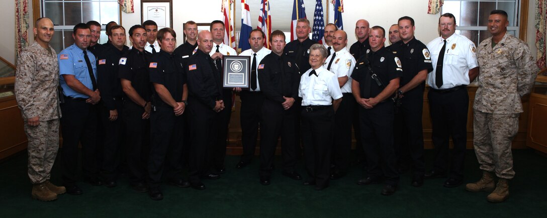 Members of Marine Corps Base Camp Lejeune’s Fire and Emergency Services Department pose for a group picture with Brig. Gen. Thomas A. Gorry (left), commanding general of Marine Corps Installations East – MCB Camp Lejeune, and Sgt. Maj. Ernest K. Hoopii (right), sergeant major of MCI East – MCB Camp Lejeune after being recognized for achieving national accreditation. Earning national accreditation is an honor for fire stations across the country and speaks volumes on the quality of work the department exemplifies while doing its job. (Official Marine Corps photo by Lance Cpl. Scott W. Whiting) 

