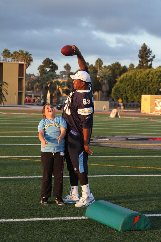Johnnie Troutman, Chargers guard, playfully holds a football over a member of the Junoir Chargers Training Camp Oct. 9 aboard Marine Corps Recruit Depot San Diego. The training camp is part of National Football League's Play 60 event and is supported by the Sports Training Academics Recreation/ Police Athletic League. Troutman, teammate David Molk, members of the San Diego Police Department and Marines volunteered their time to pratice football drills with children.