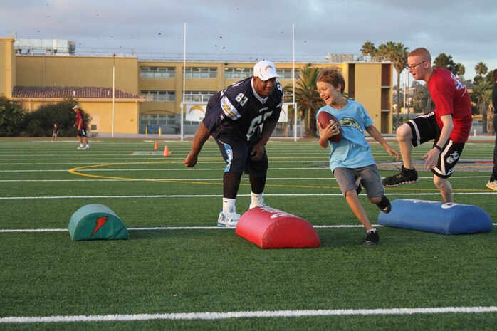 Johnnie Troutman, Chargers guard, attempts to knock a football out of a participant of the Junoir Chargers Training Camp Oct. 9 aboard Marine Corps Recruit Depot San Diego. 