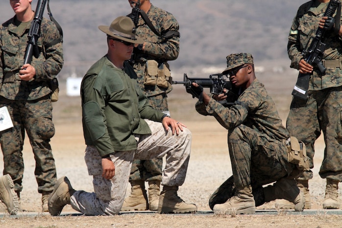 Sgt. Ryan Salinas, primary marksmanship instructor, Weapons Company, Weapons and Field Training Battalion, helps a recruit of Company F, 2nd Recruit Training Battalion, with his kneeling position while snapping in Oct. 2 at Edson Range aboard Marine Corps Base Camp Pendleton. Recruits snap in for hours, learning to be comfortable with each position before they head to the firing line the following week. 