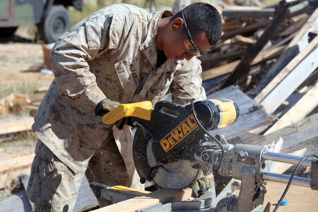 Lance Cpl. Michael H. Alfaro cuts wood using a miter saw at the Central Training Area, near Camp Hansen, Oct. 3. Alfaro is a combat engineer with Company A, 9th Engineer Support Battalion, 3rd Marine Logistics Group, III Marine Expeditionary Force. 
